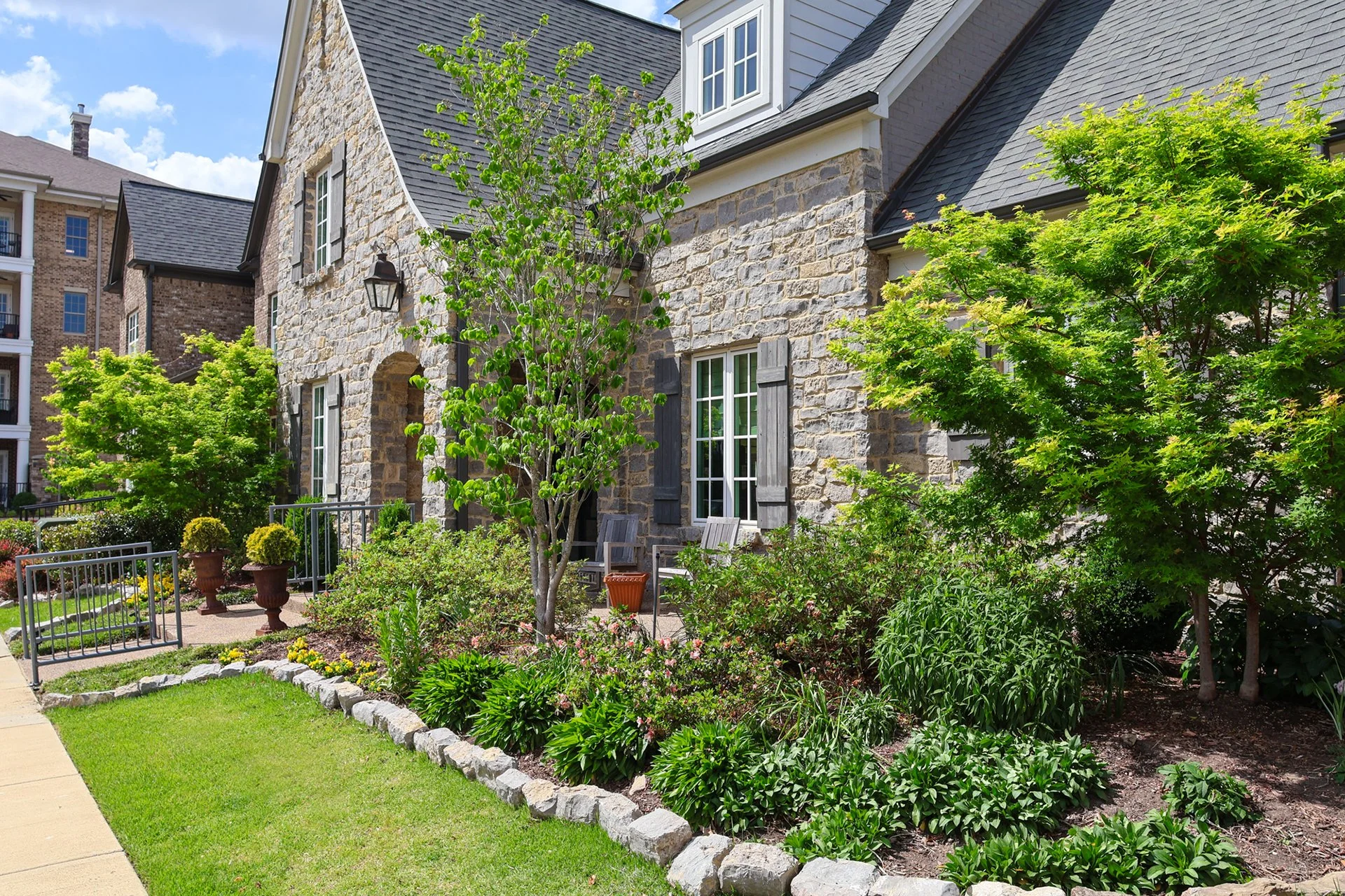 exterior view showcasing landscaped garden and custom porch seating area
