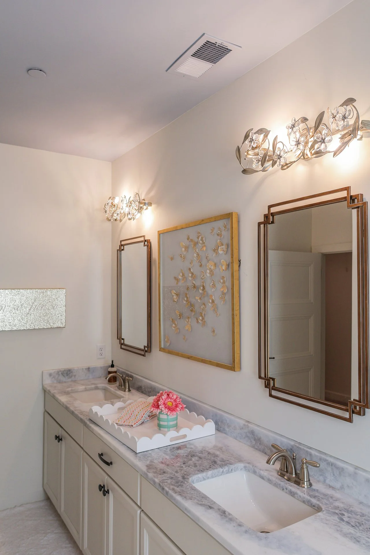 custom childrens double bathroom with gold accented mirrors and lighting