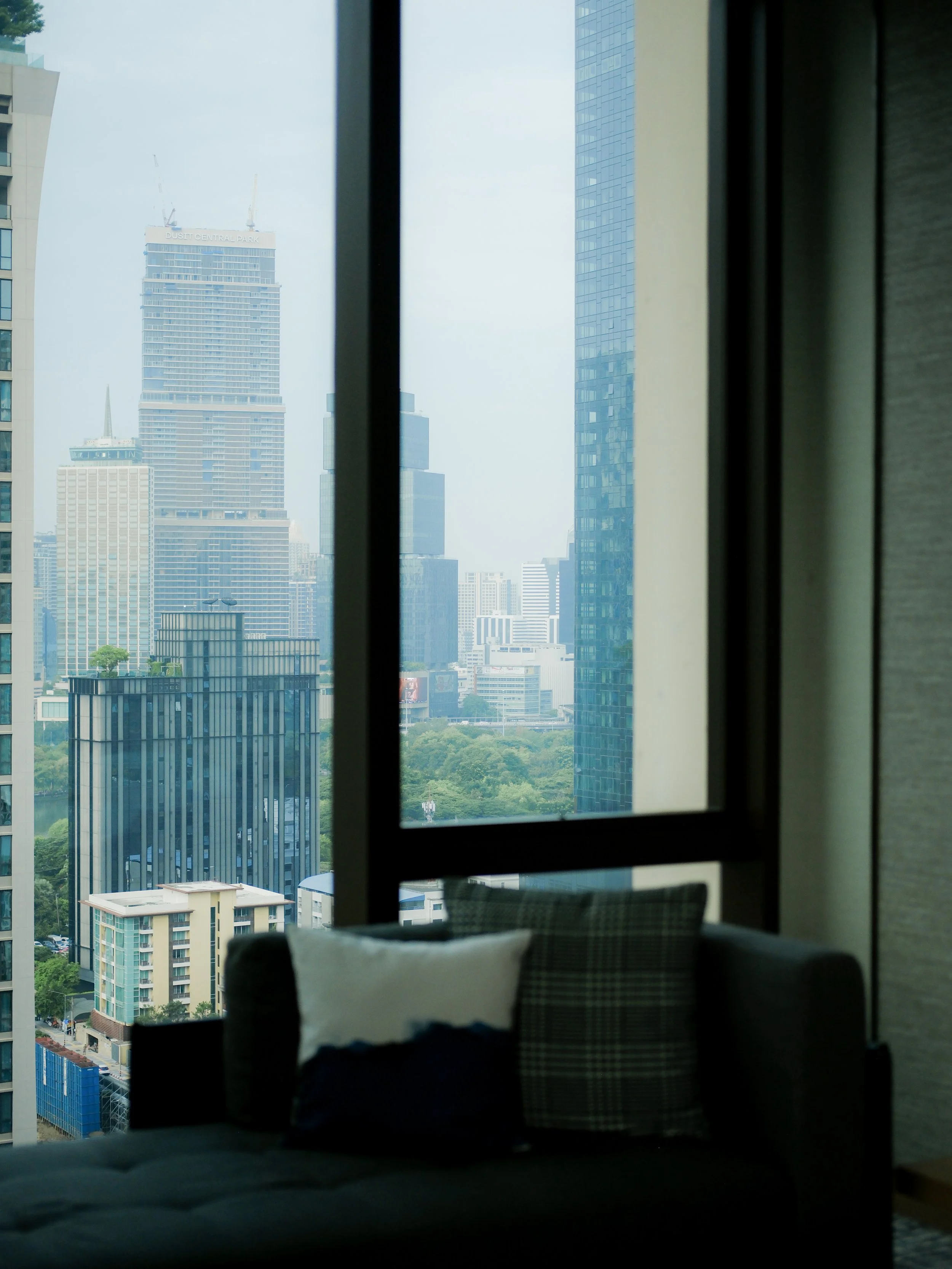 Kimpton Maa Lai Bangkok hotel room with floor-to-ceiling window and Bangkok city skyline view — luxury hotel photography by Dillon Atsiil