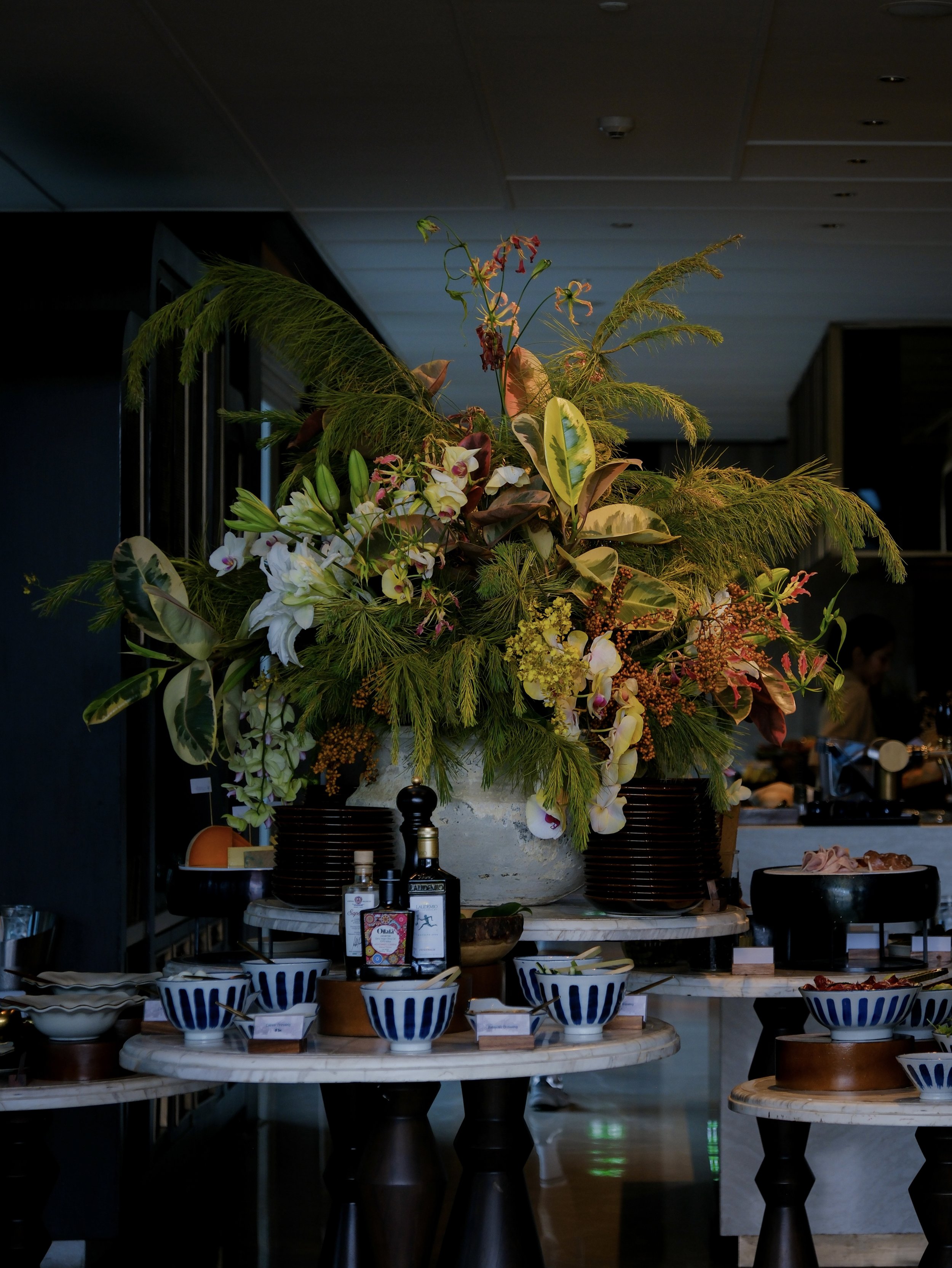 Capella Bangkok hotel dining table with moody floral centerpiece — luxury hotel interior photography