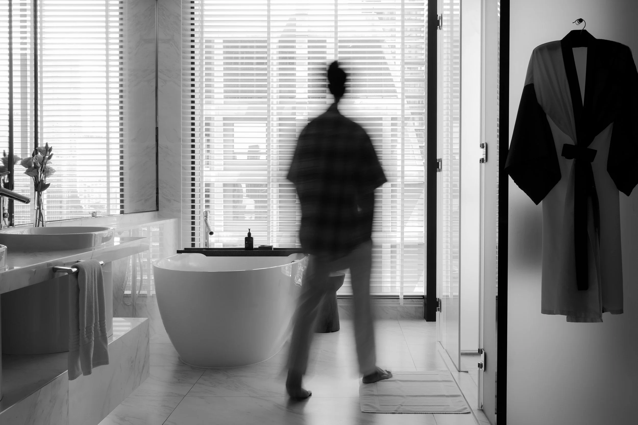 Kimpton Maa Lai Bangkok hotel room with silhouette figure by floor-to-ceiling window and city view — editorial hotel photography
