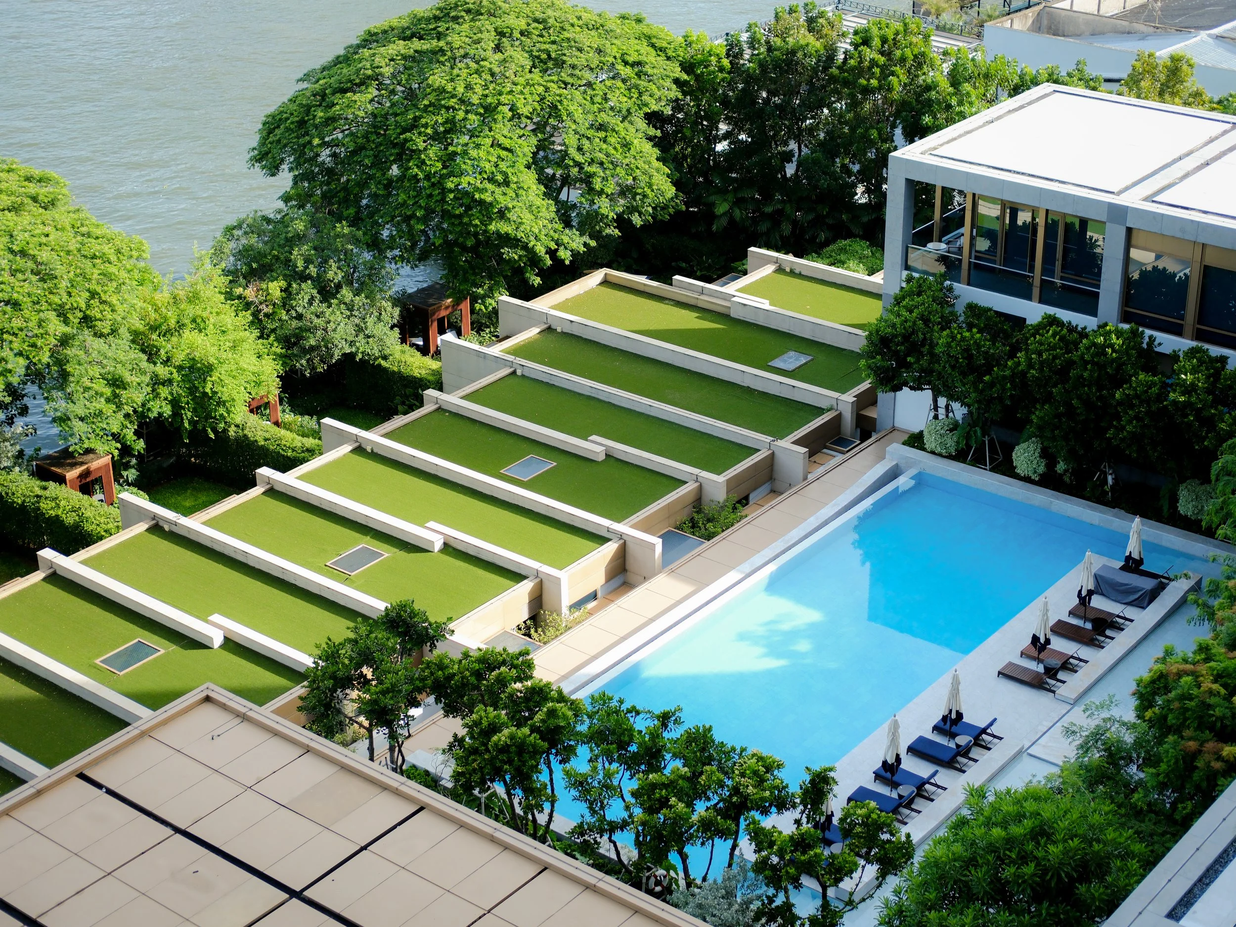 Capella Bangkok reflecting pool with floating lily planters and riverside facade — luxury hotel photography by Dillon Atsiil, Bangkok 2026