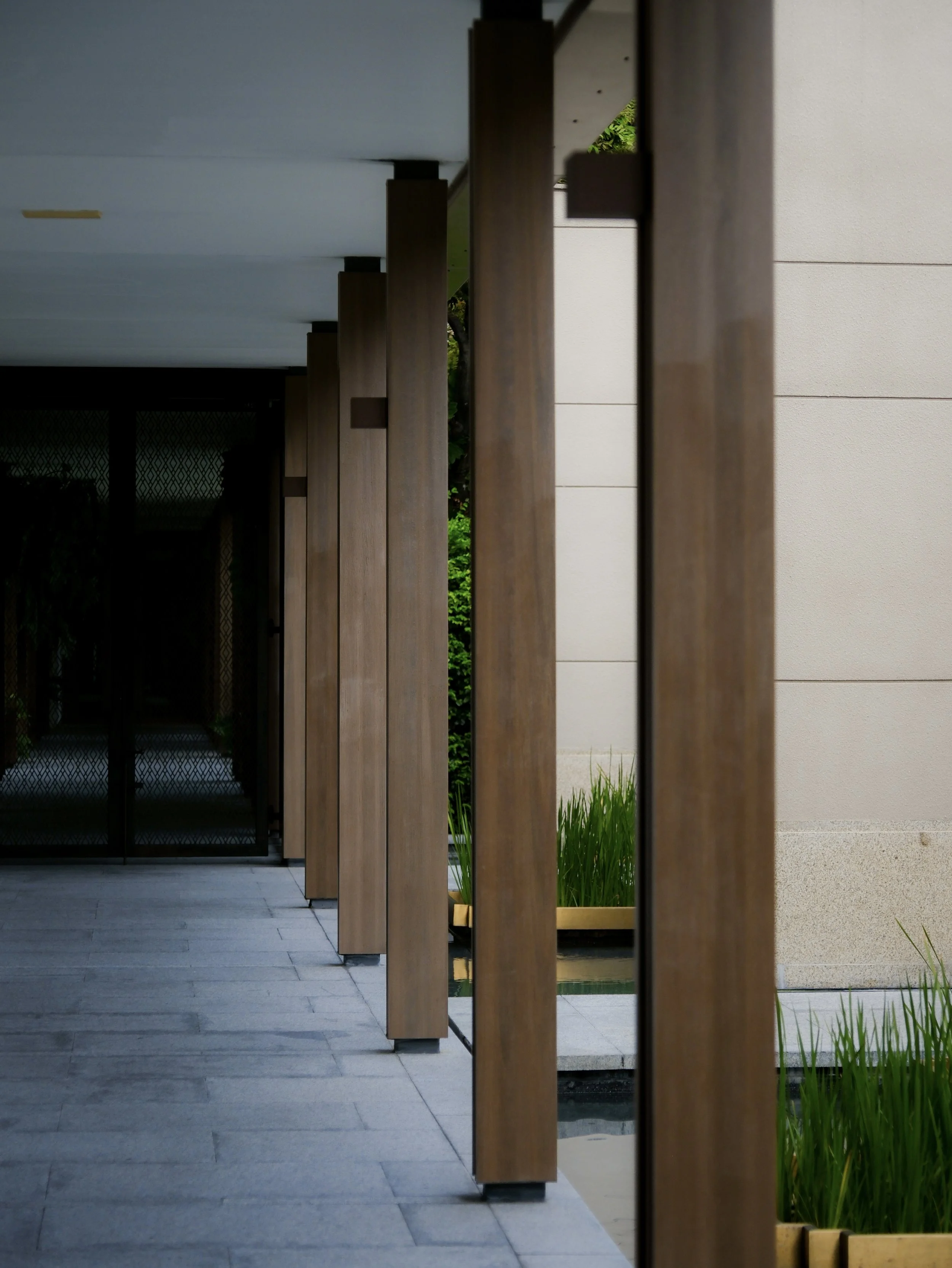 Capella Bangkok hotel corridor with wooden slat screen and warm lighting — luxury hotel architectural photography
