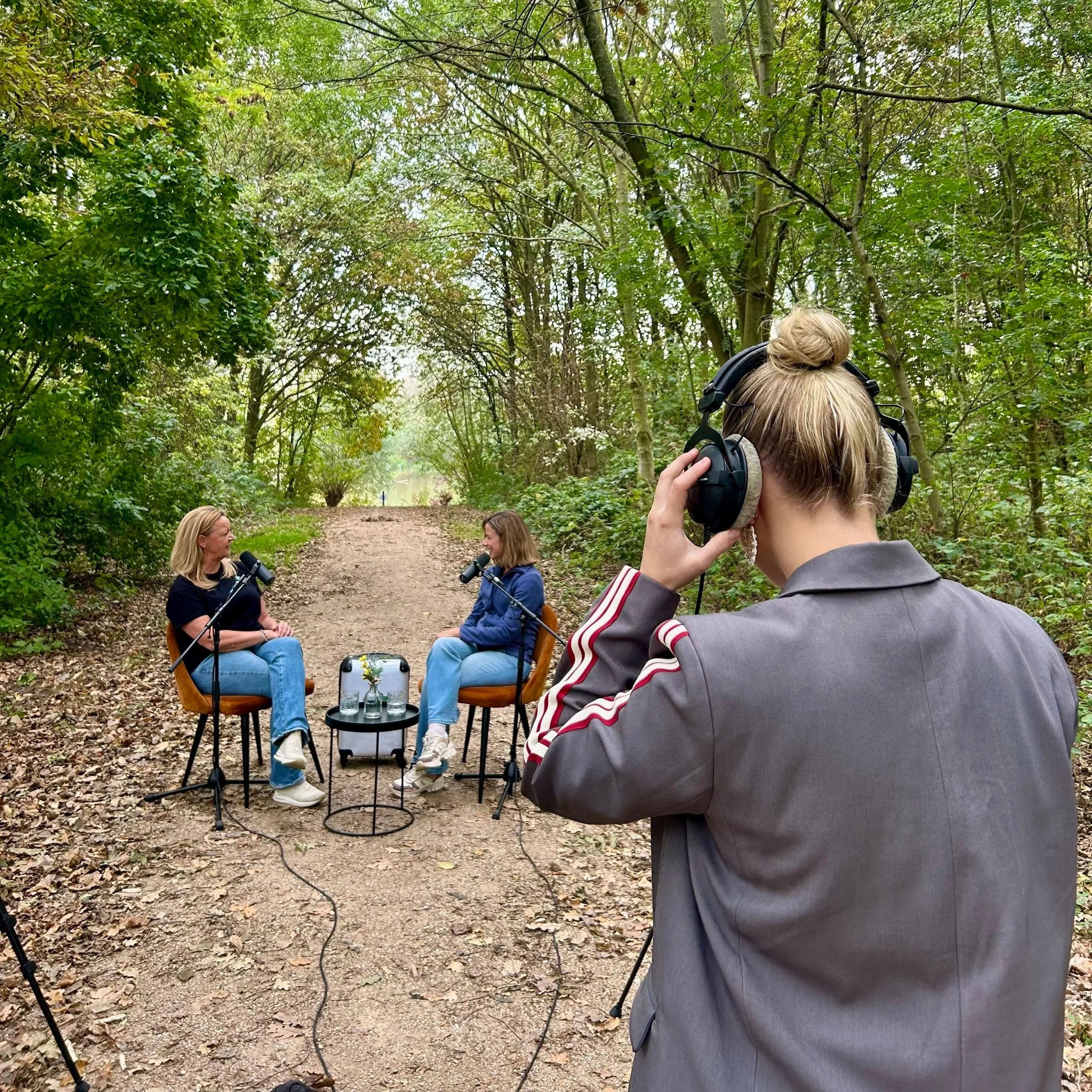 de buiten pedagogen praten met elkaar in een podcast buiten in het bos terwijl podcast studio westland de audio checkt