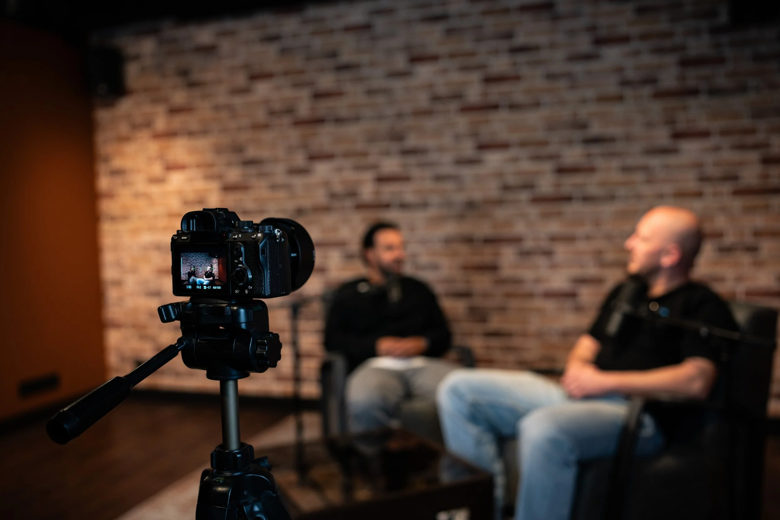 een sony a7iii filmt de twee mannen die aan het praten zijn in een podcast in de studio van podcast studio westland