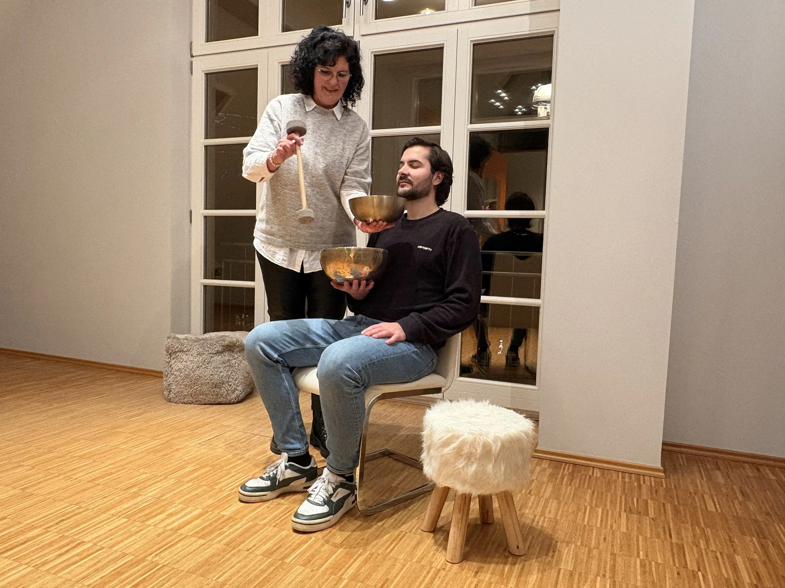 Beate Eulenbach begleitet einen Teilnehmer bei einer Klangschalenentspannung in Rengsdorf bei Koblenz