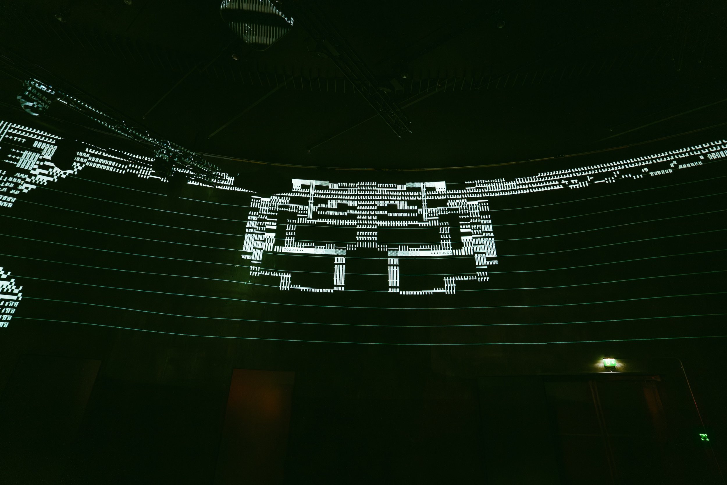 Digital LED art installation displaying abstract pixelated patterns on a dark wall.