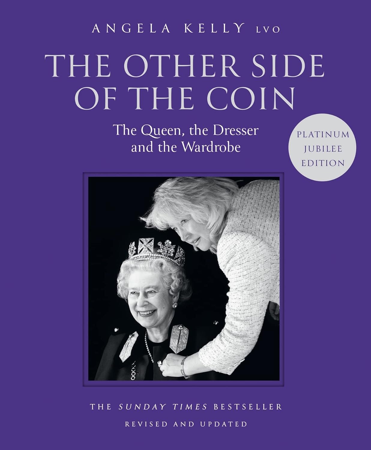 Book cover titled "The Other Side of the Coin: The Queen, the Dresser and the Wardrobe" by Angela Kelly, featuring a black and white photo of two women, one wearing a crown. The cover is purple and marked as a "Platinum Jubilee Edition."