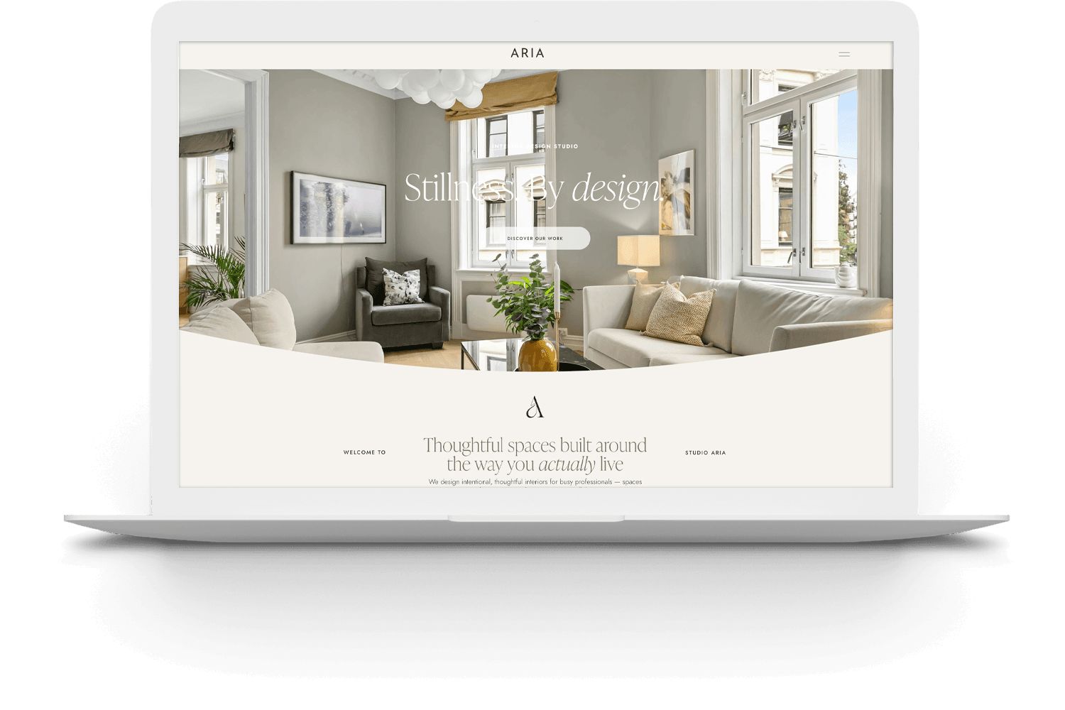 Screenshot of a website homepage showcasing a bright, modern living room with large windows, a white sofa with pillows, a gray armchair, and minimalistic decor.