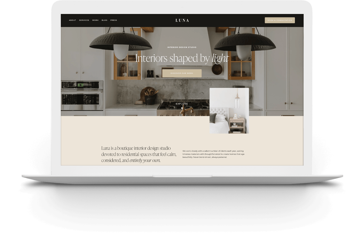 A laptop displaying a modern interior design website with a kitchen photo and the headline Interiors shaped by light.