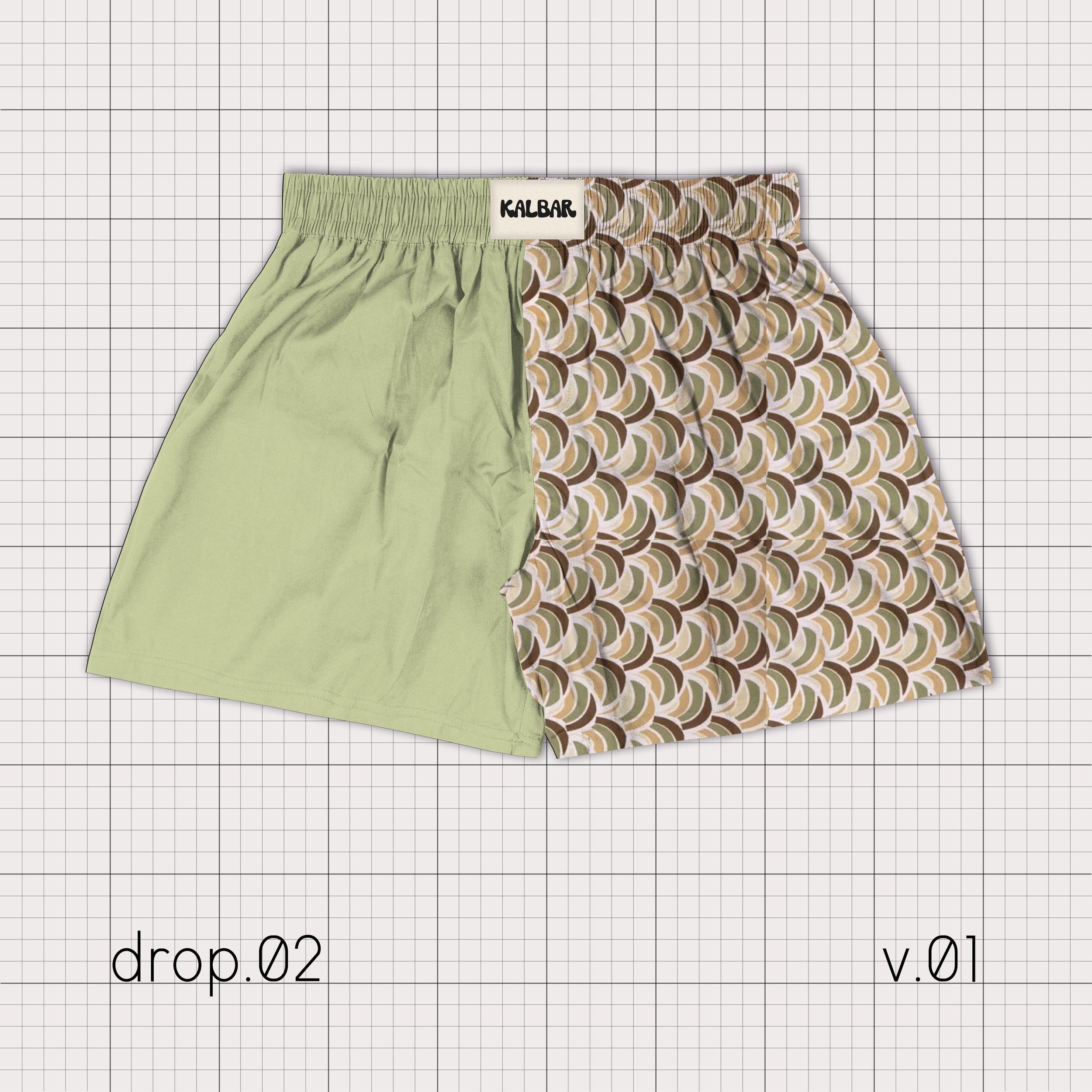 Un short avec une moitié verte et l'autre moitié avec un motif géométrique multicolore, sur un fond quadrillé, avec les textes 'drop.02' et 'v.01' visibles.