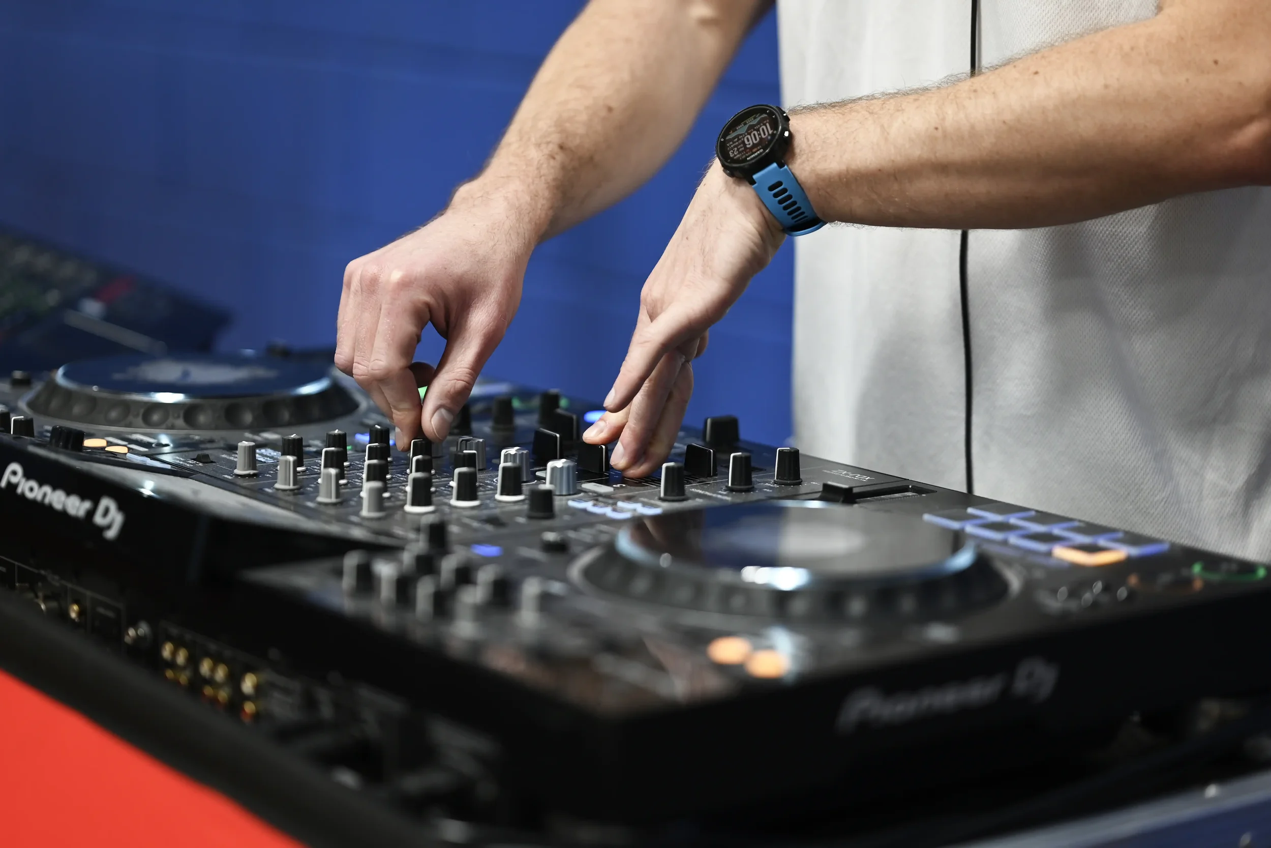 Photograph of a DJ's desk and hands operating the desk during an event