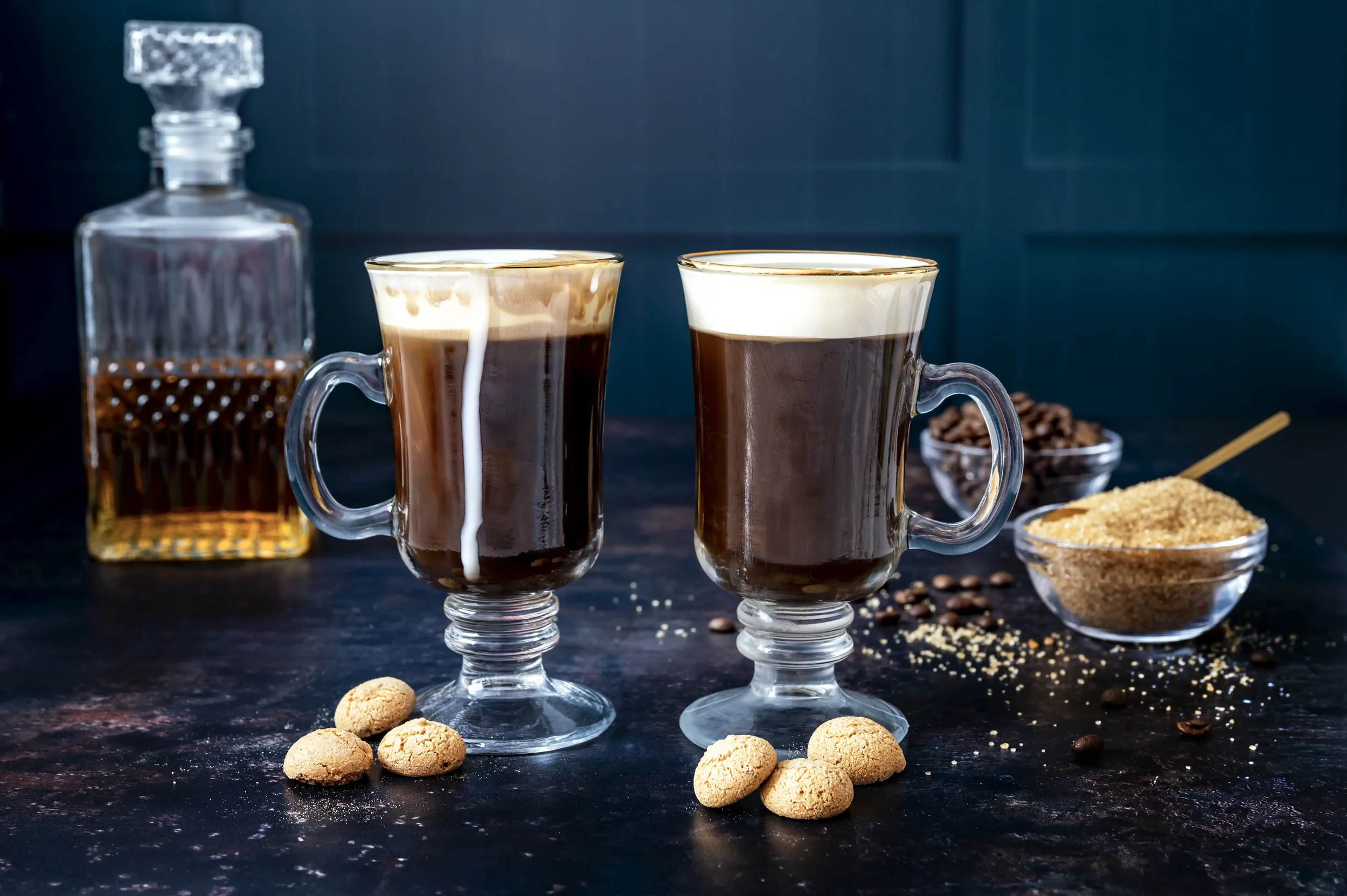 Image of two Irish Coffee drinks against a dark background.