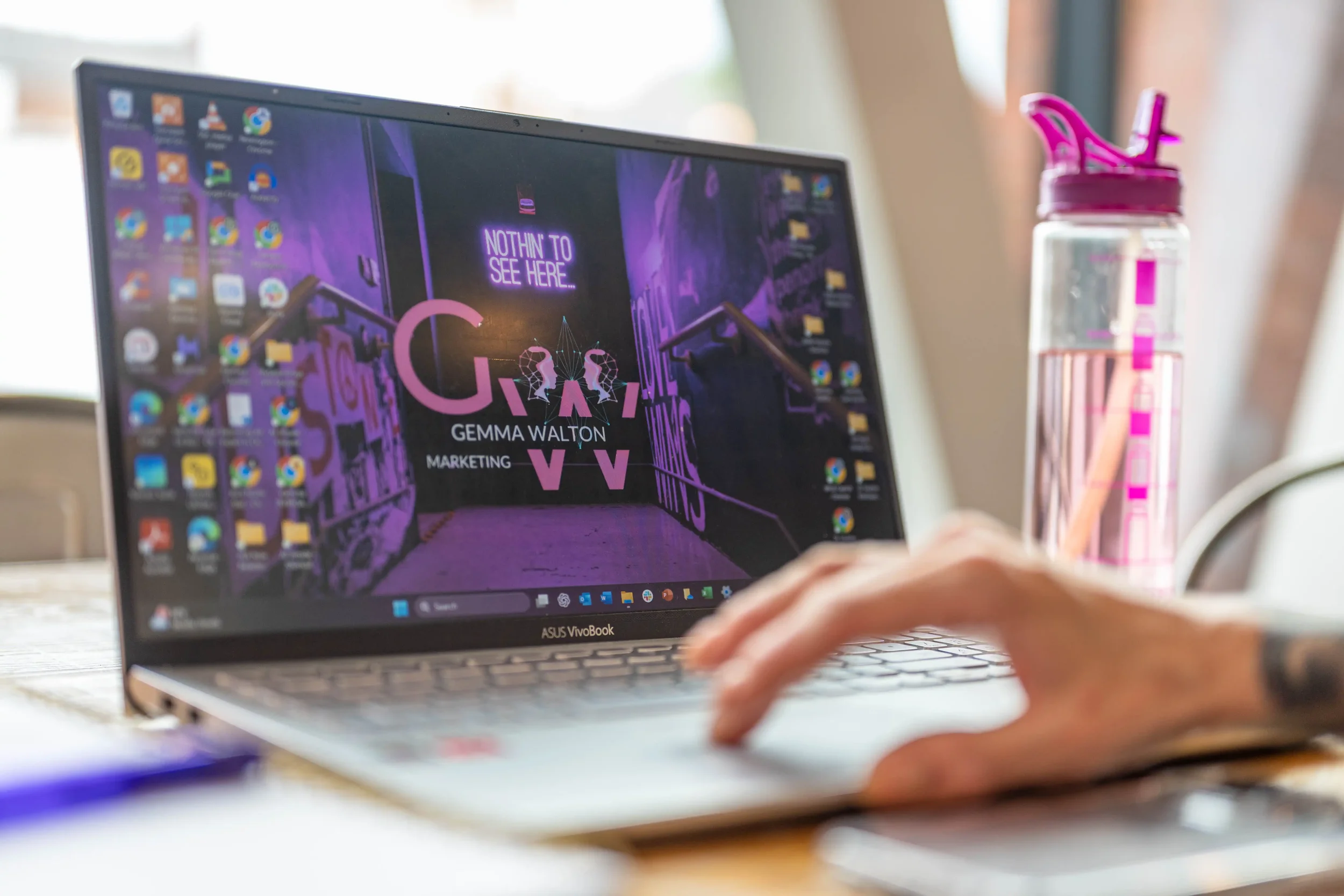 Close-up photograph of a laptop screen showing a picture of a business logo in black and purple