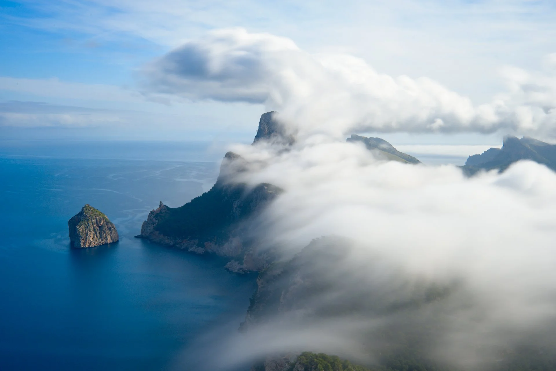 Morning fog covers the misty mountains in Formentor.