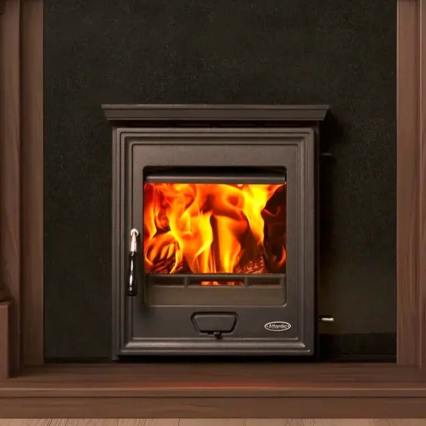 Black fireplace insert with a glass door showing flames inside, set in a wall with wooden and black surroundings.