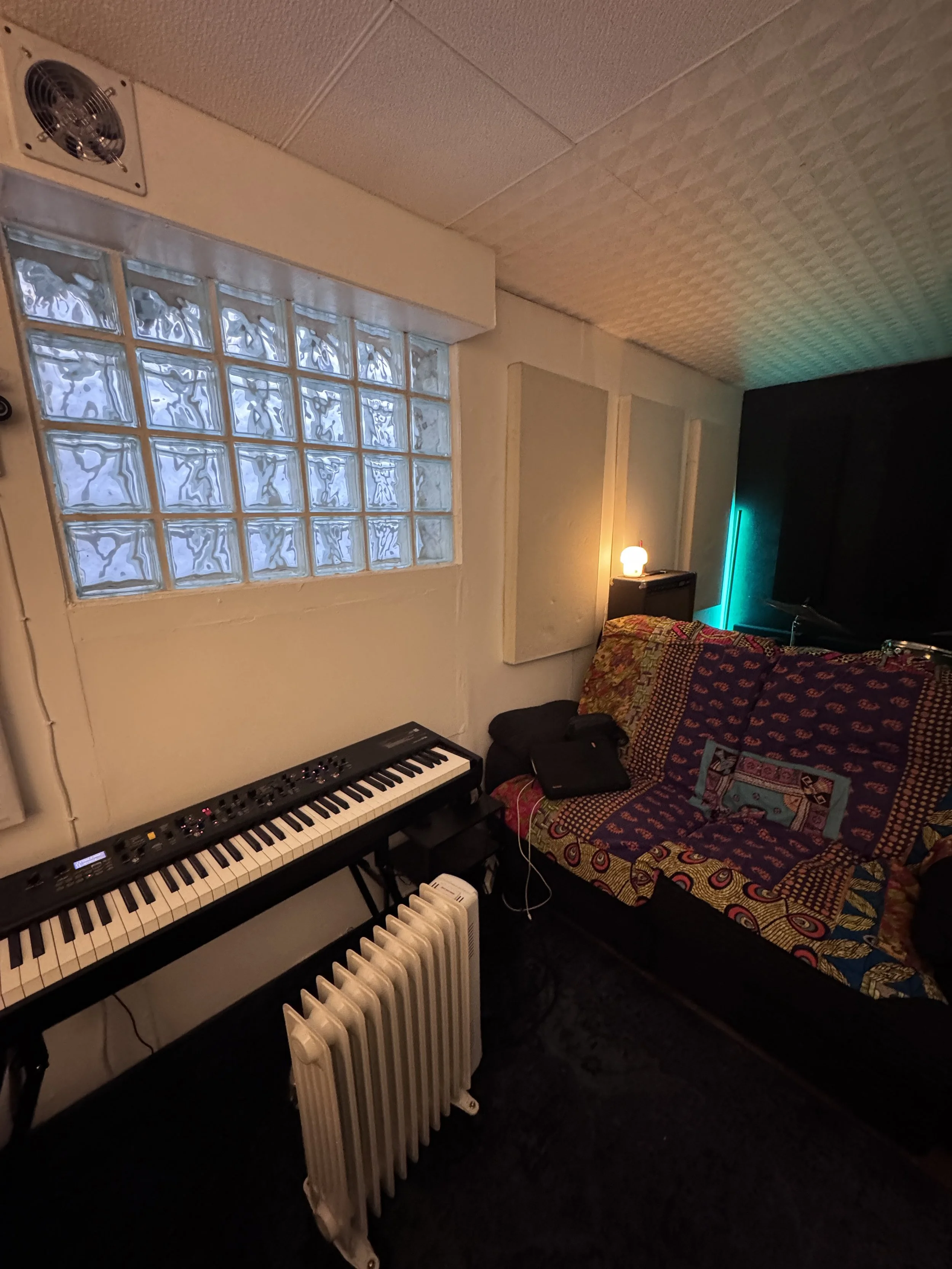 Cozy writing and recording corner at The Low Studios with electric piano and comfy sofa.