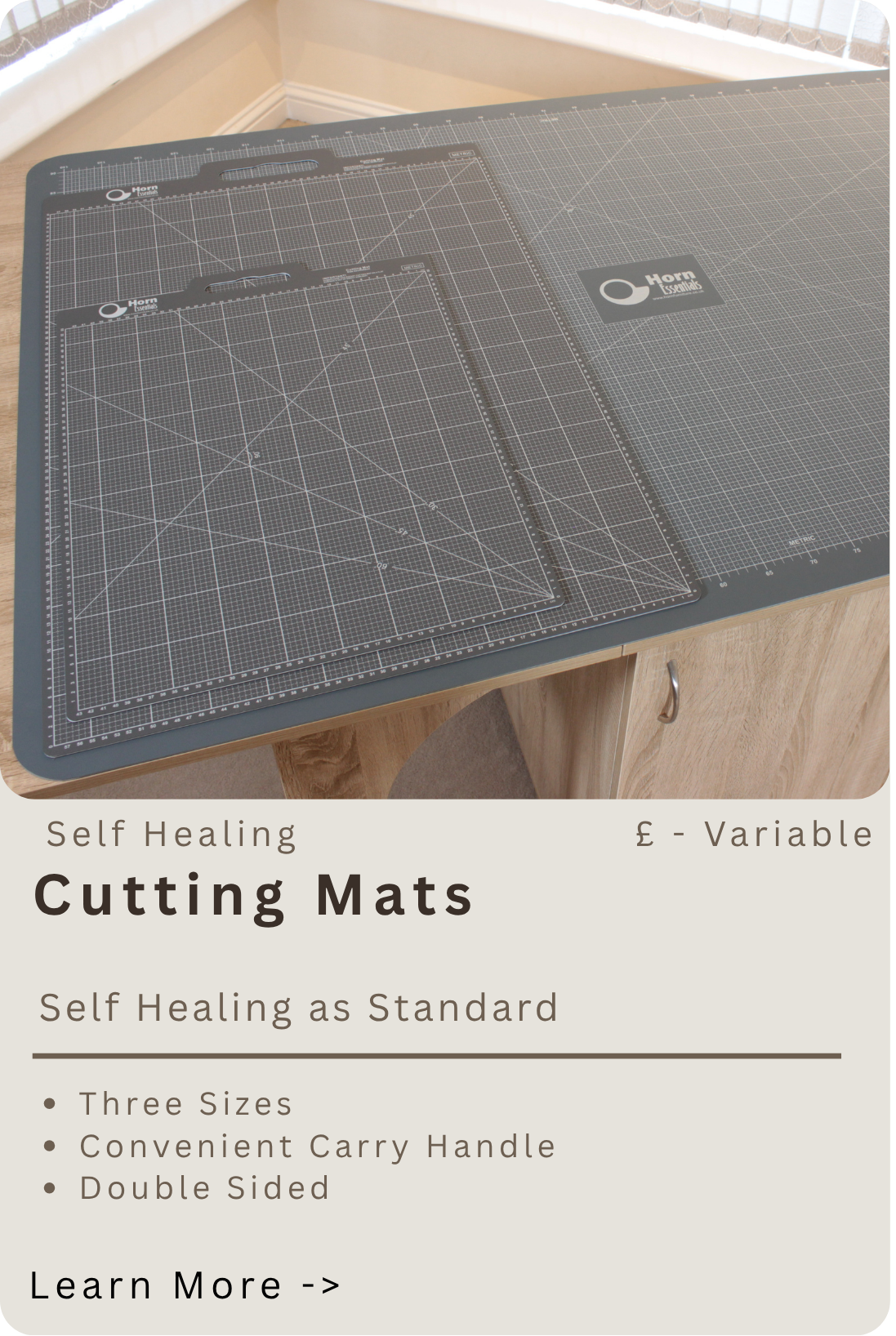 Set of three self-healing cutting mats of varying sizes with grid and measurements, placed on a wooden surface.