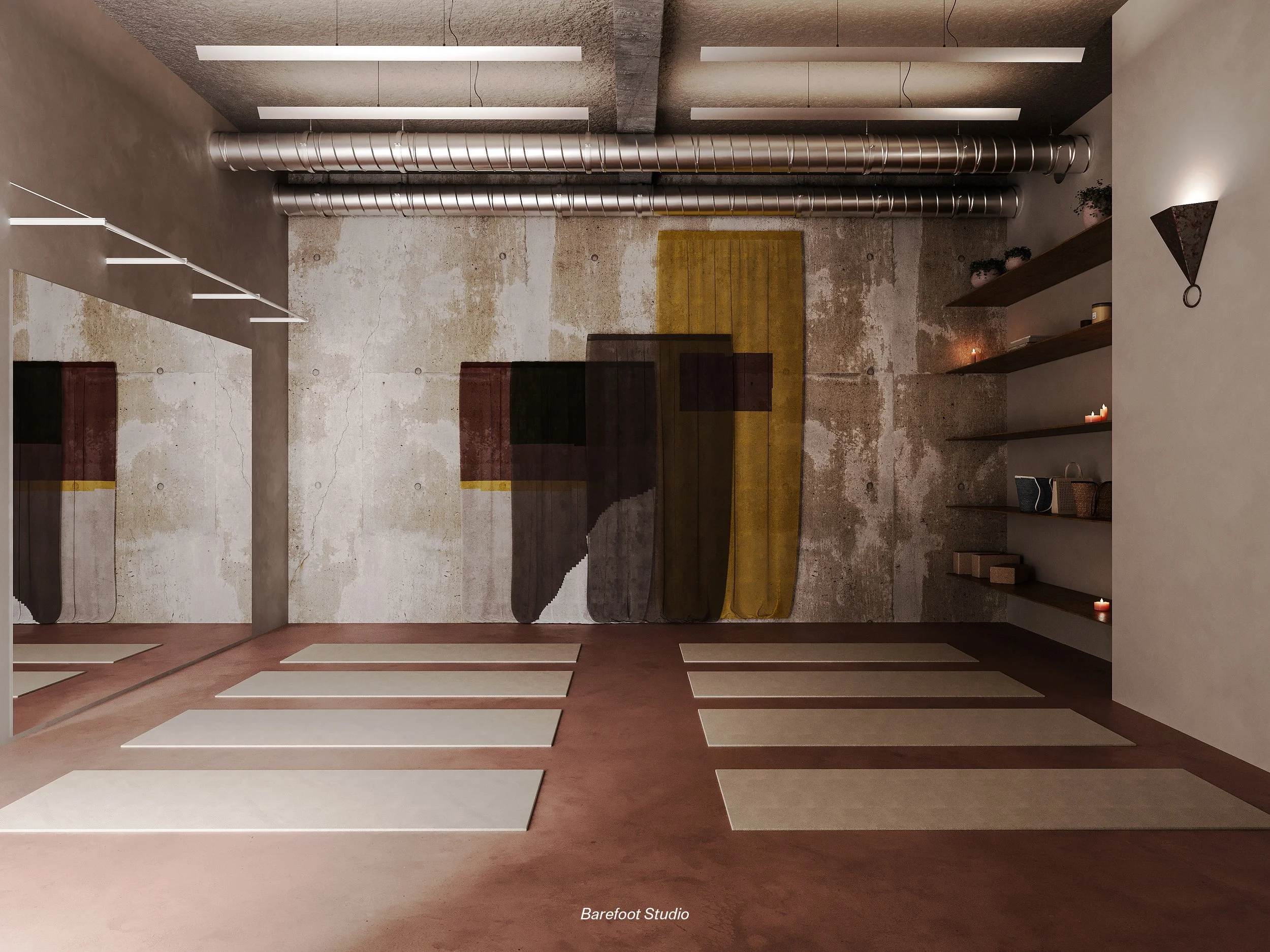 A yoga studio with yoga mats laid out on a reddish-brown floor, a textured concrete wall with colorful hanging rugs, industrial pipes on the ceiling, and floating shelves with plants and candles.