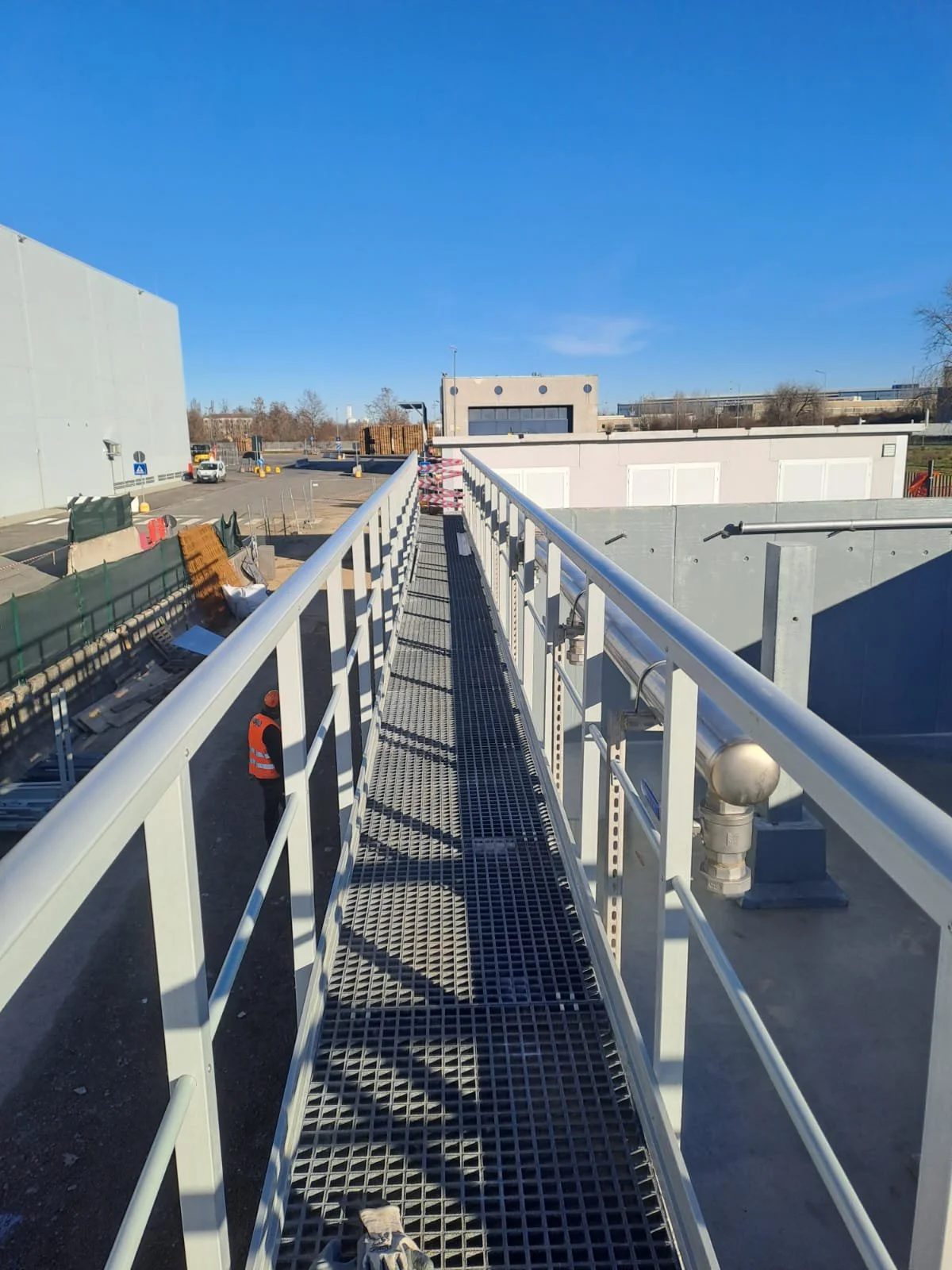 Passerella metallica su un cantiere edilizio sotto un cielo blu
