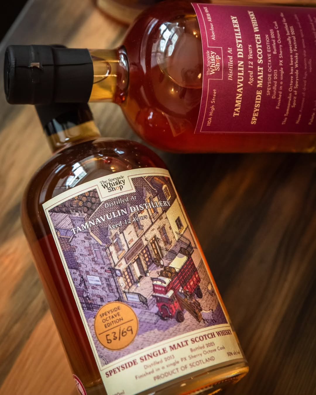 Bottles of Tannavulin Distillery Speyside Single Malt Scotch Whisky with labels and purple caps on a wooden surface.