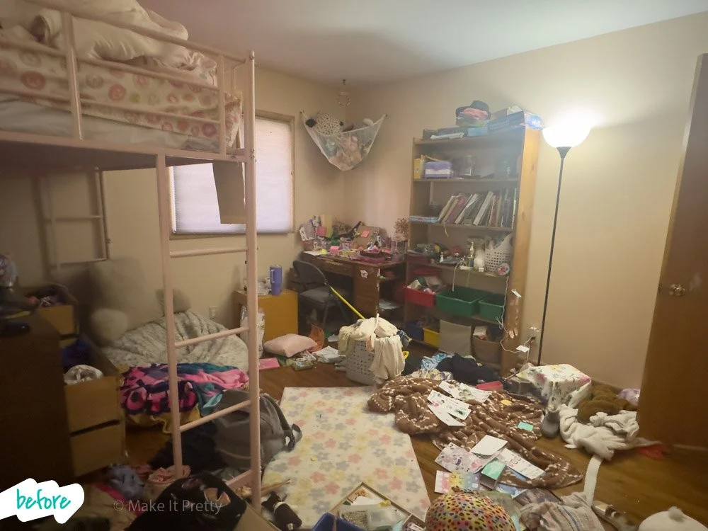 Cluttered bedroom with a loft bed, a bookshelf, and messy floor with clothes, books, and miscellaneous items.