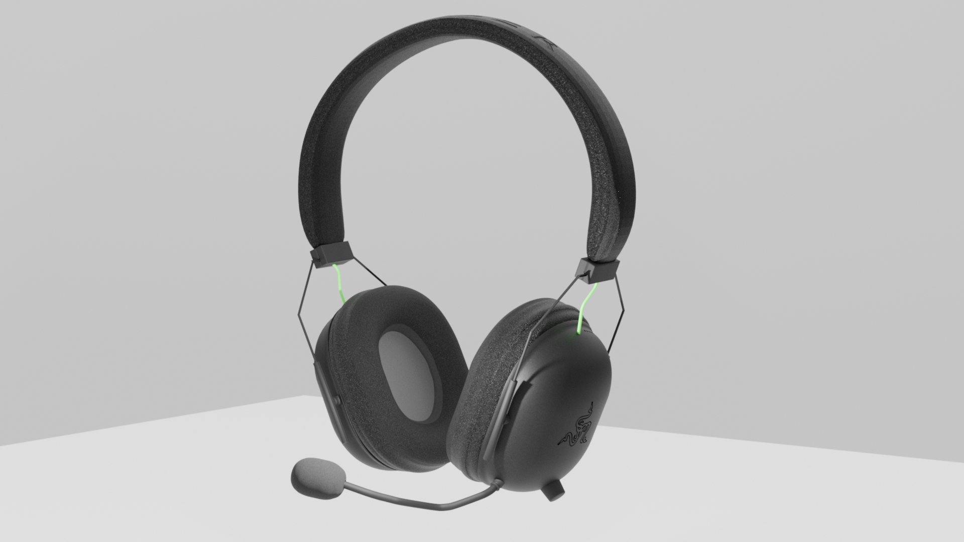 Black gaming headset with microphone and green accents and a Razer logo on the ear cups, placed on a white surface against a light gray background.
