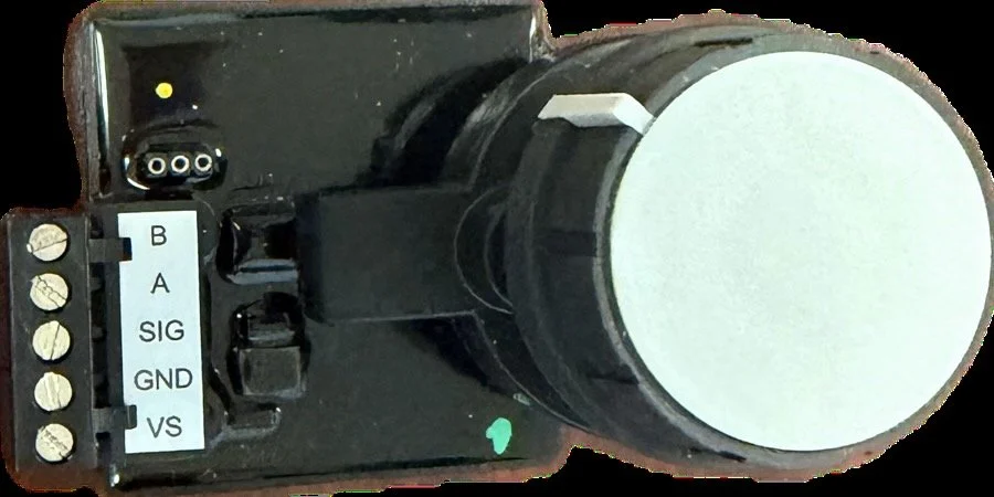 Close-up of an industrial or electronic device with a large rotary knob and terminal connections labeled B, A, SIG, GND, and VS.
