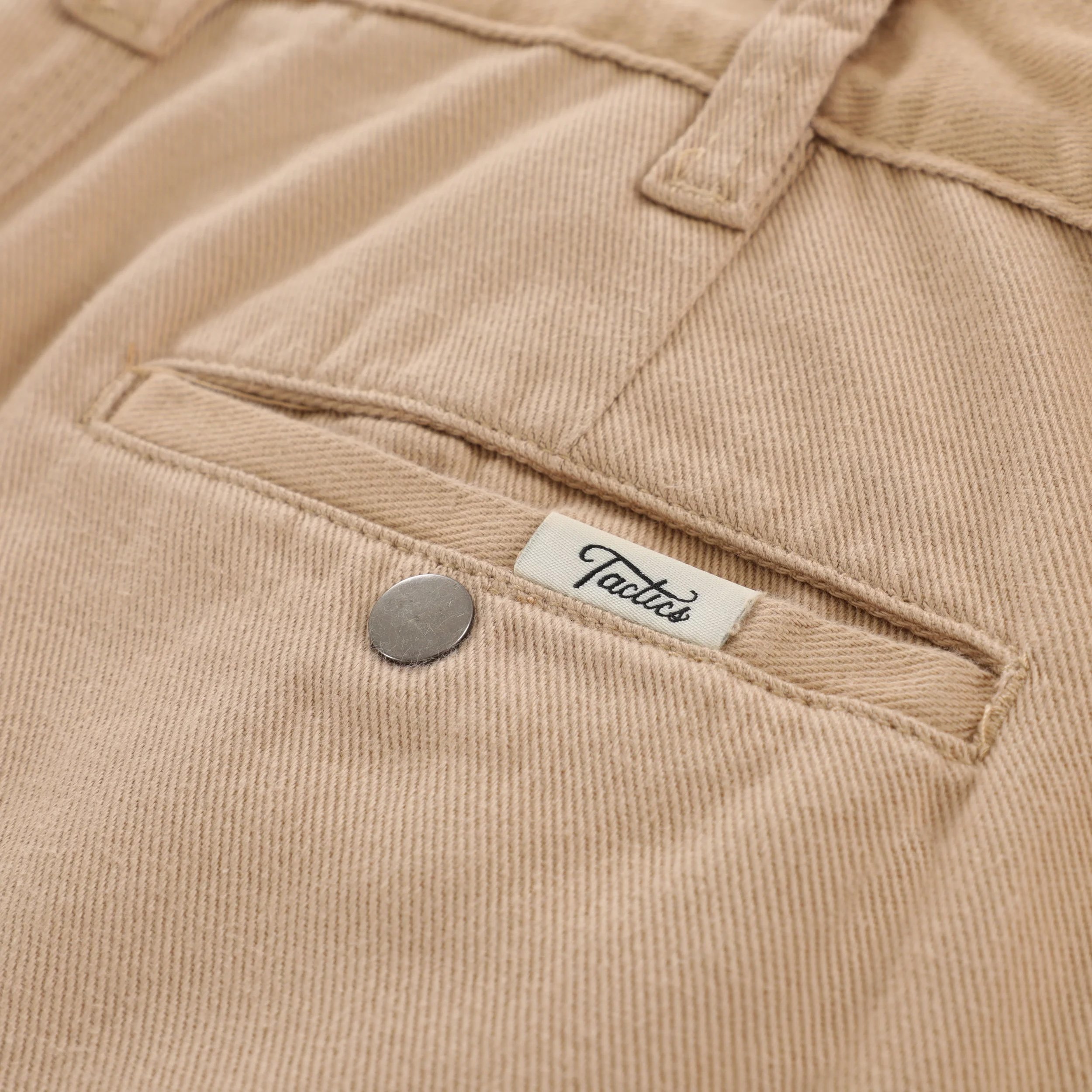 Woven clamp label rear pocket welt with snap closure on Chino Work Pant.