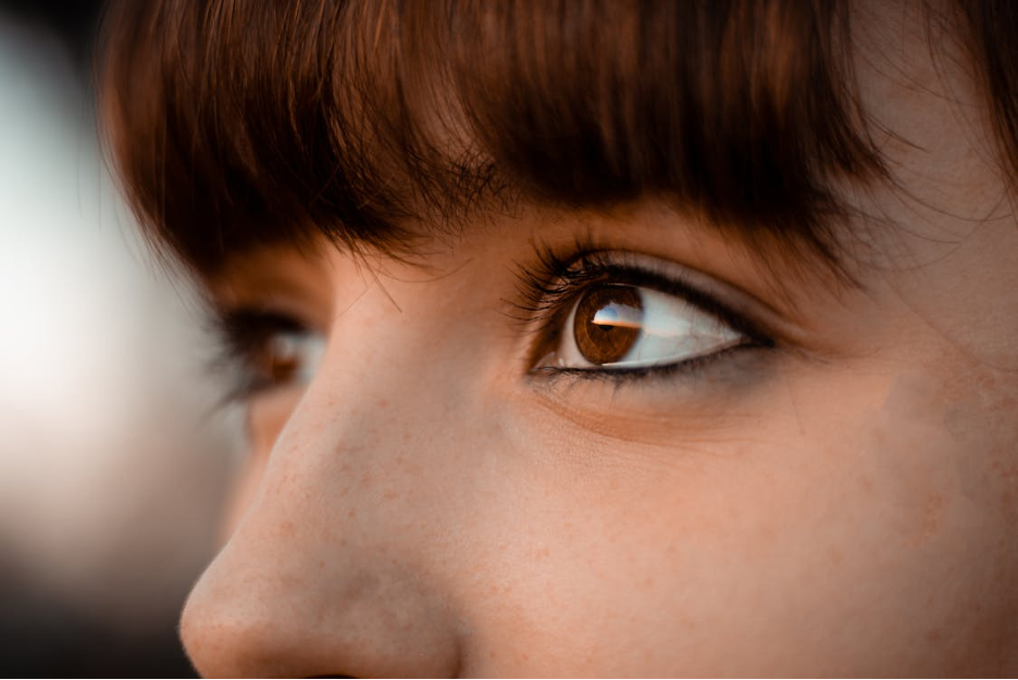 Close-up of a person's brown eye and part of their face with brown hair.