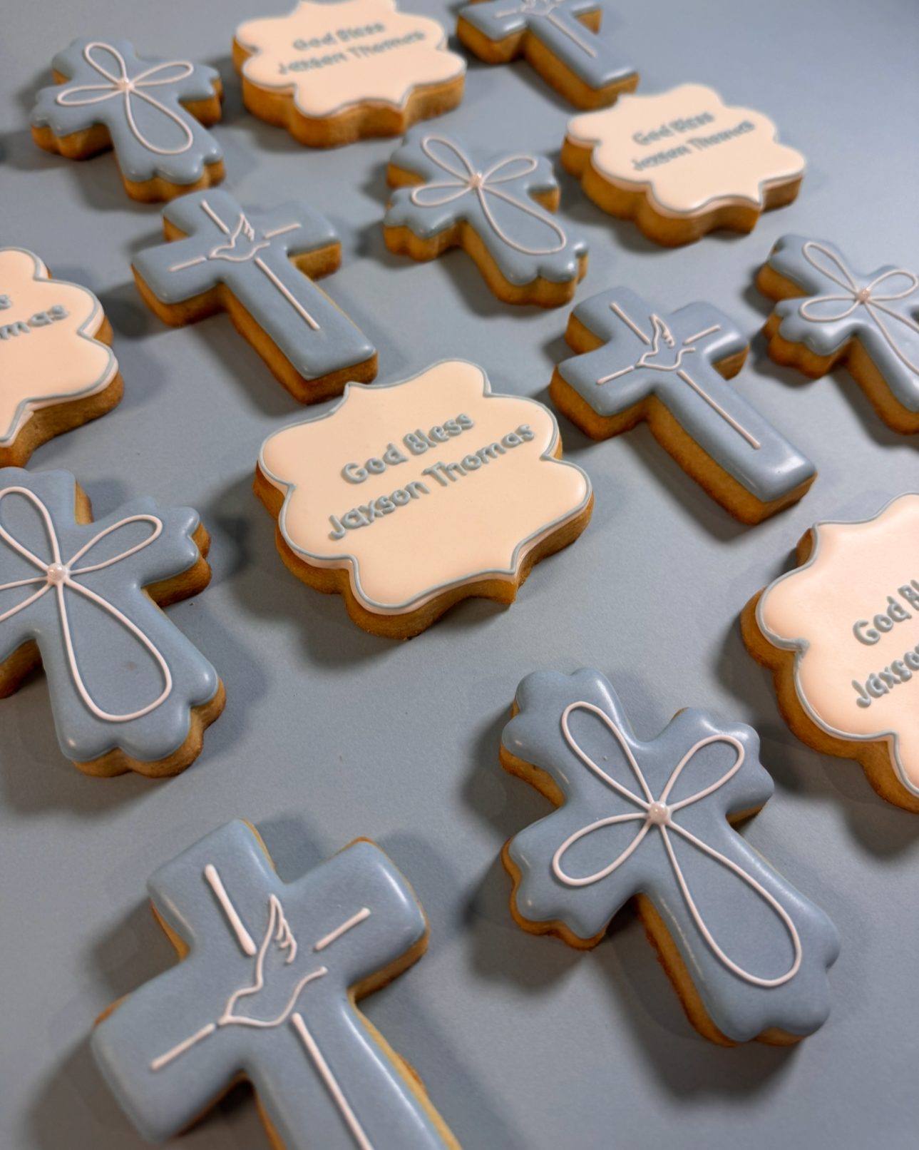Decorative baby shower cookies with religious crosses, angels, and prayer bubbles, featuring the message 'God bless Jason Thomas'.