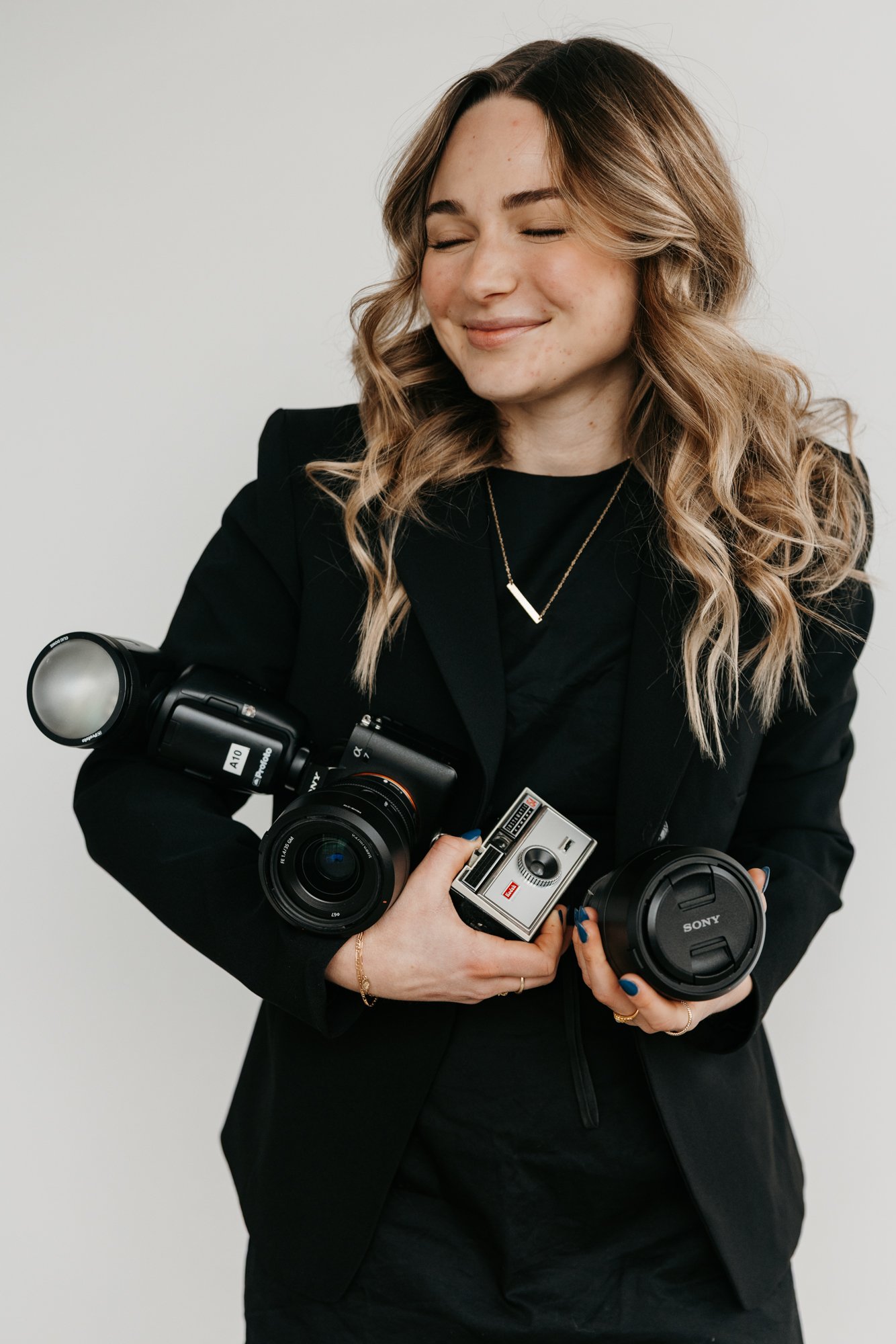 Female Photographer holding different cameras