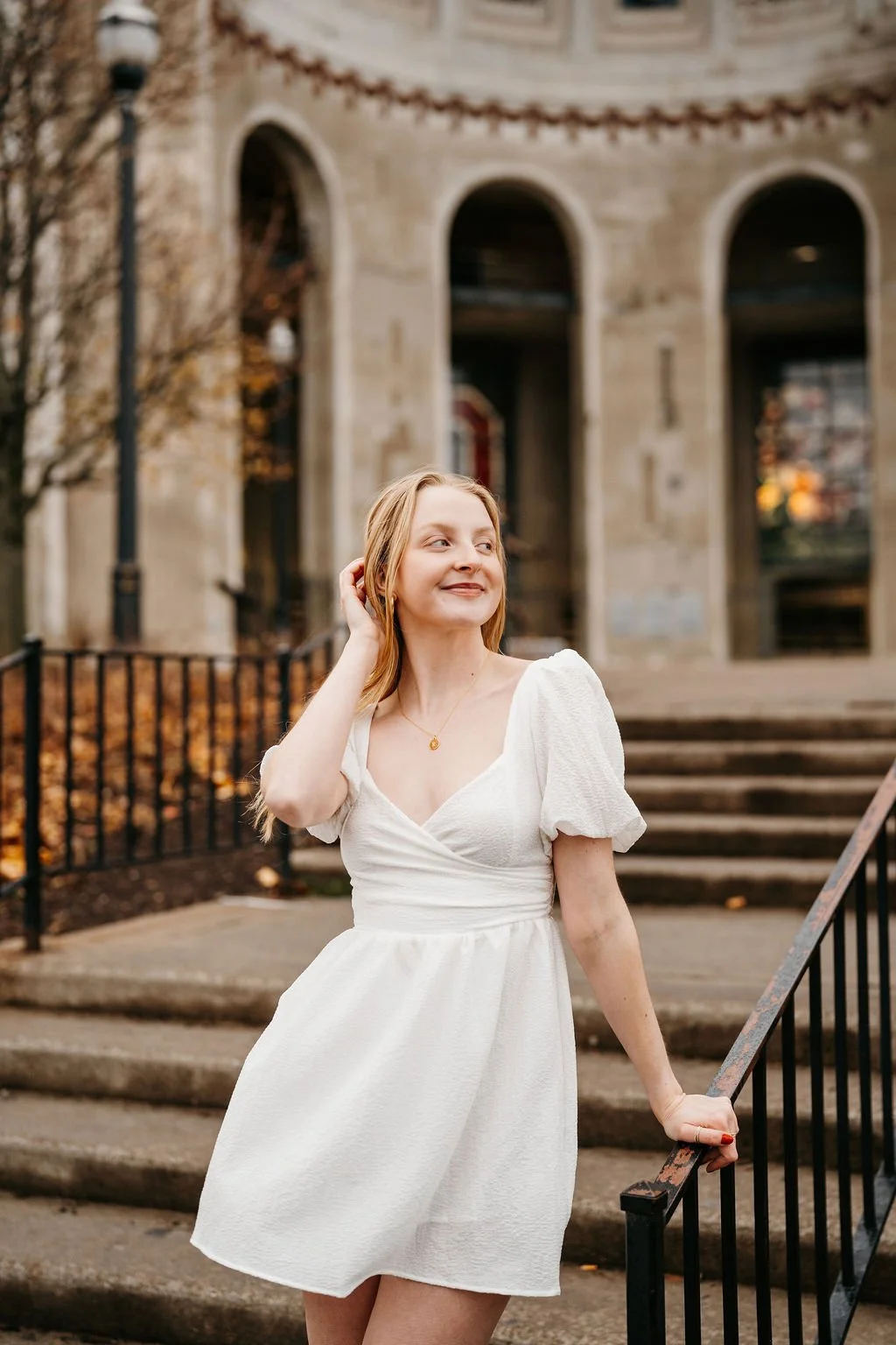 Girl in a white dress standing on steps outside
