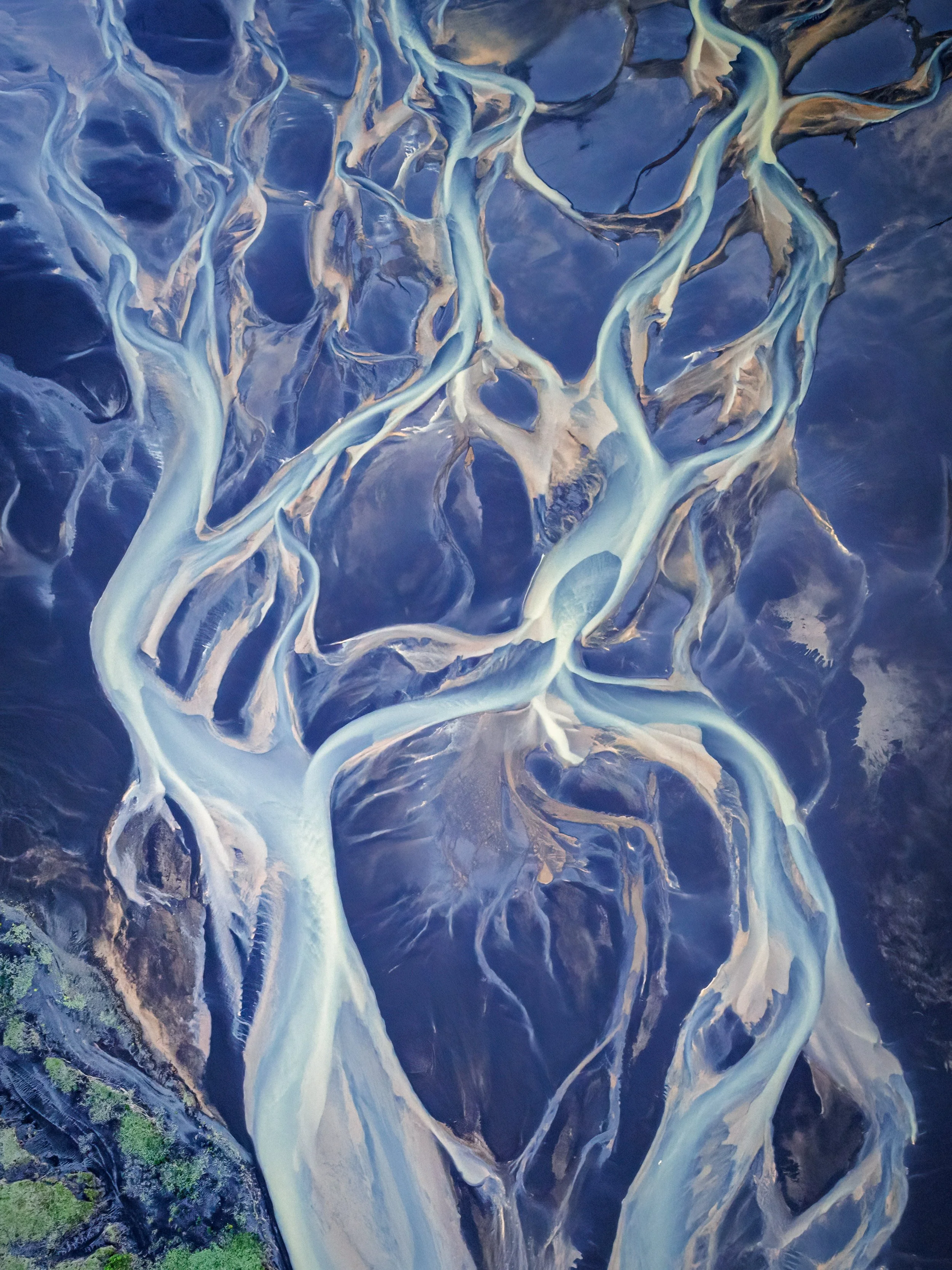 Aerial image of Iceland’s glacial rivers branching across black sand, resembling the lifeblood of Midgard in Norse mythology.