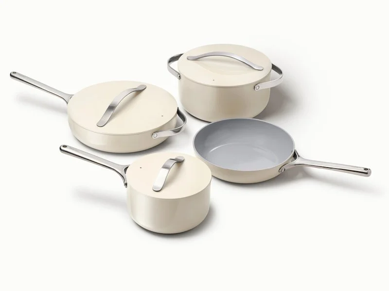 Four cream-colored non-stick saucepans with silver handles and lids