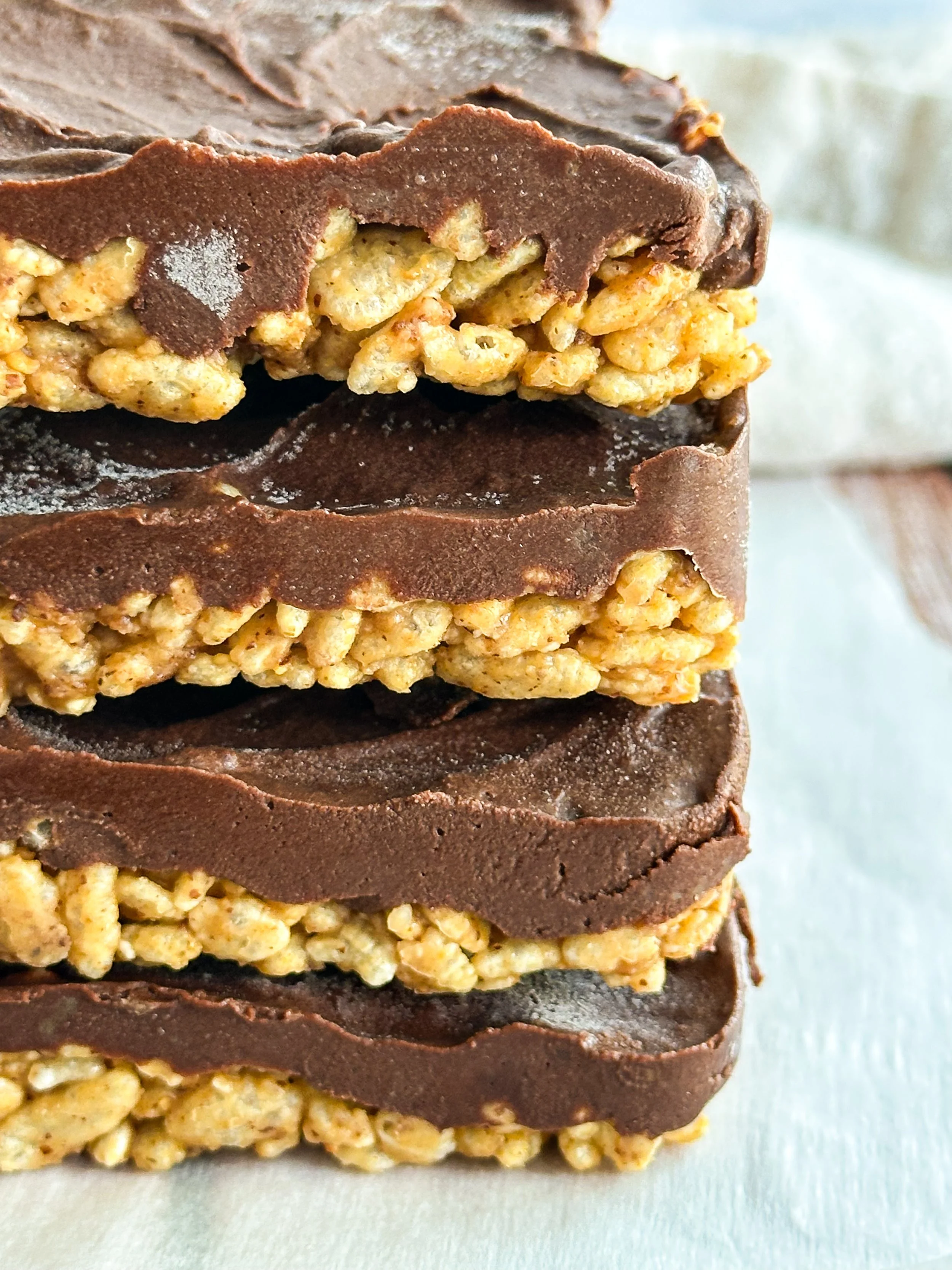 Stack of no-bake chocolate crispie bars with visible crunchy and creamy layers