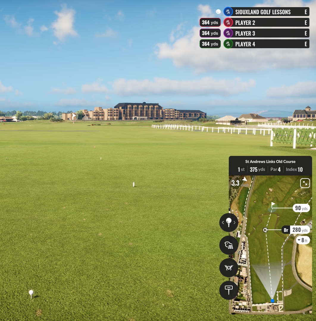 A golf course with a digital overlay showing distance markers and player names, with a clear sky and buildings in the background.