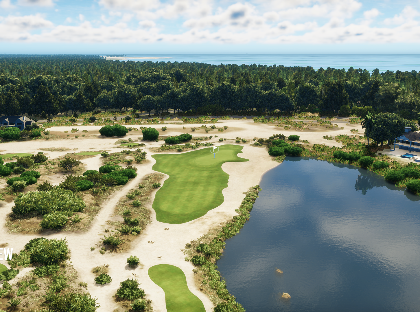 Aerial view of a golf course with lush green fairways, surrounded by a sandy landscape, near a body of water, and with a forested area in the background near the coast.