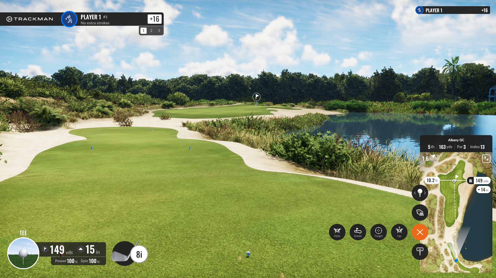 A golf course with a water hazard on the right side, a green in the distance with a flag, and a clear blue sky with some clouds.