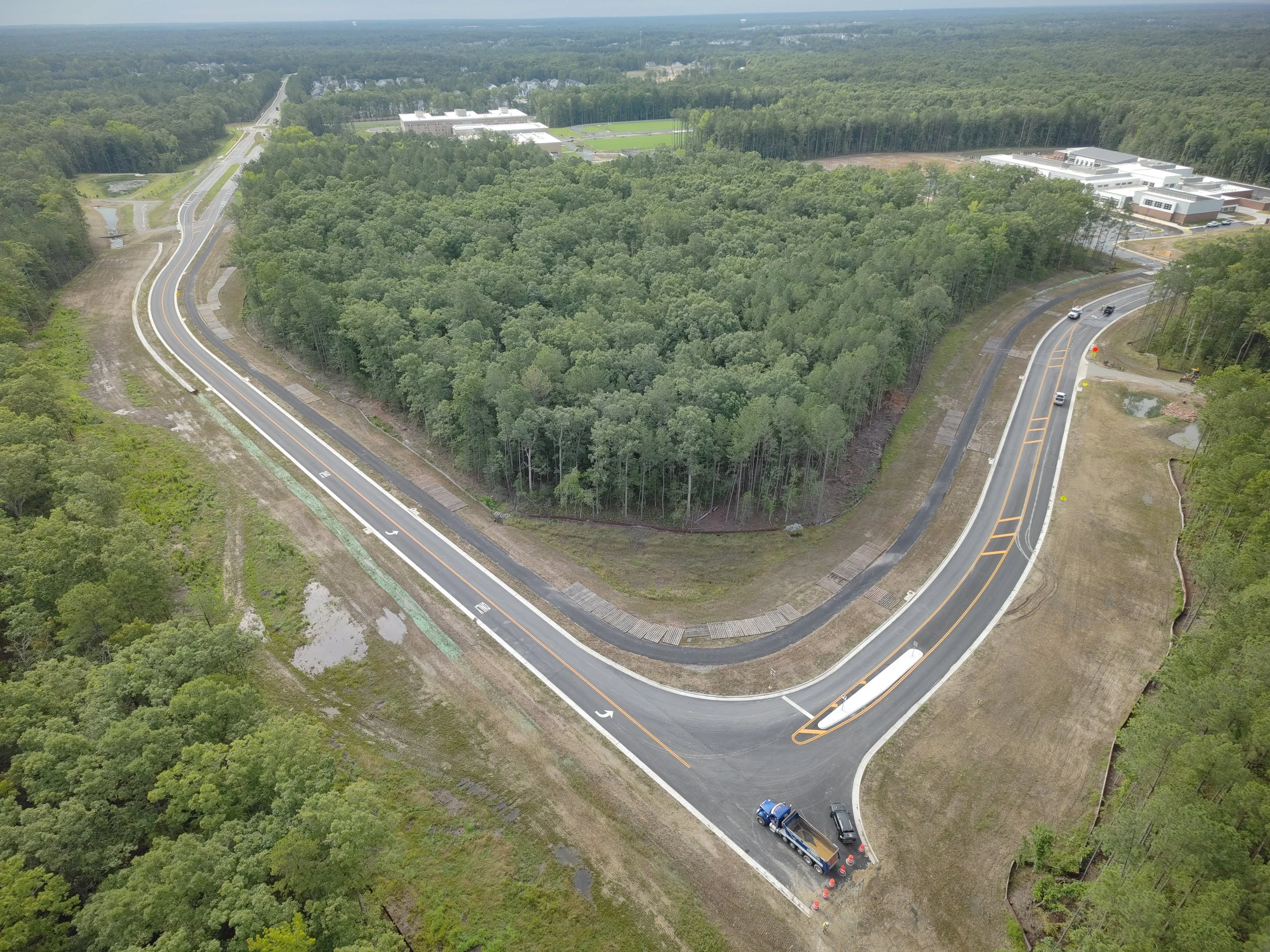 Roadway work continues with curb/underdrain installation and paving to follow. Work on the bridge reaches final stages with sidewalk and railing installation.