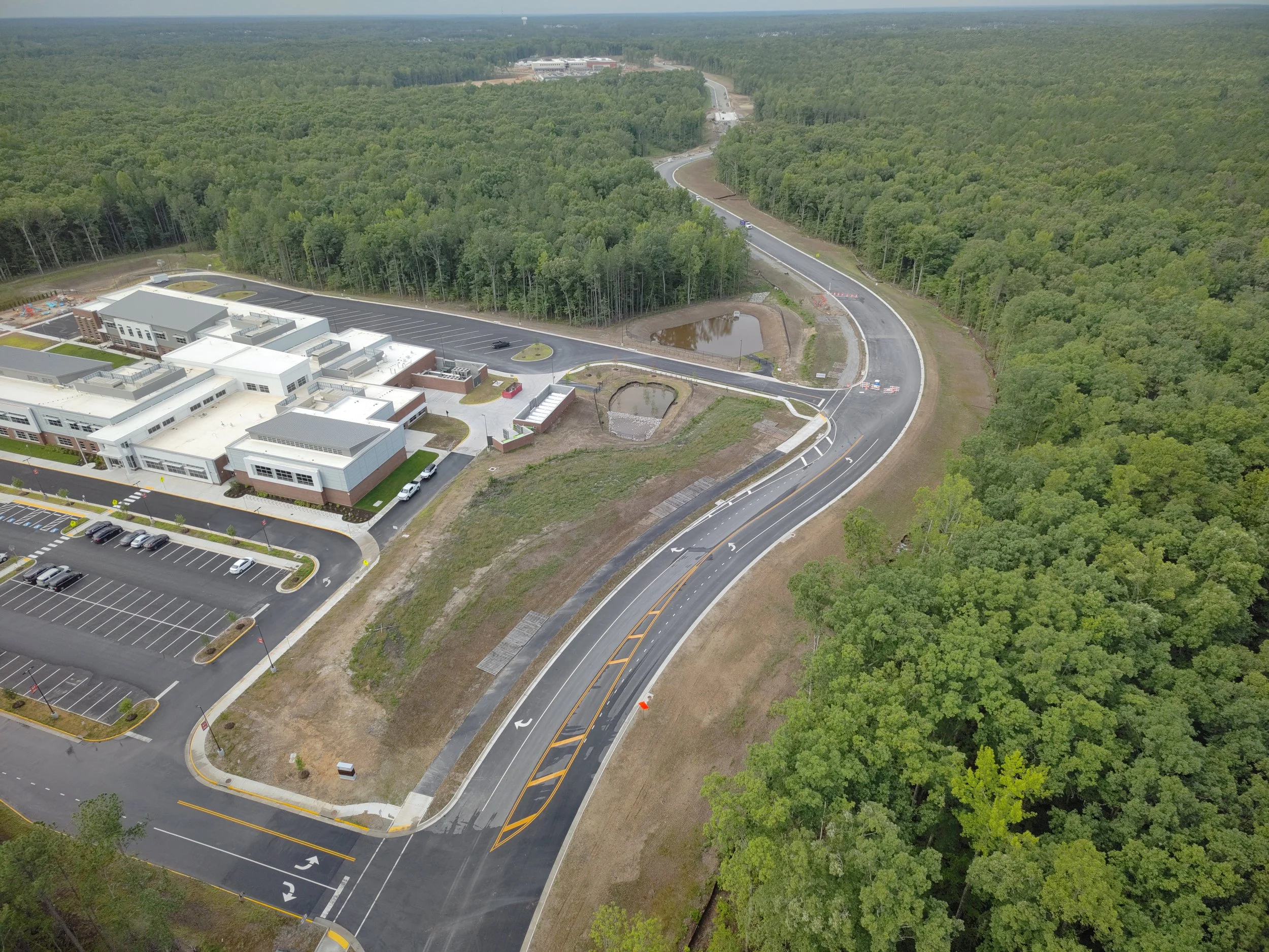 Roadway work continues with curb/underdrain installation and paving to follow. Work on the bridge reaches final stages with sidewalk and railing installation.