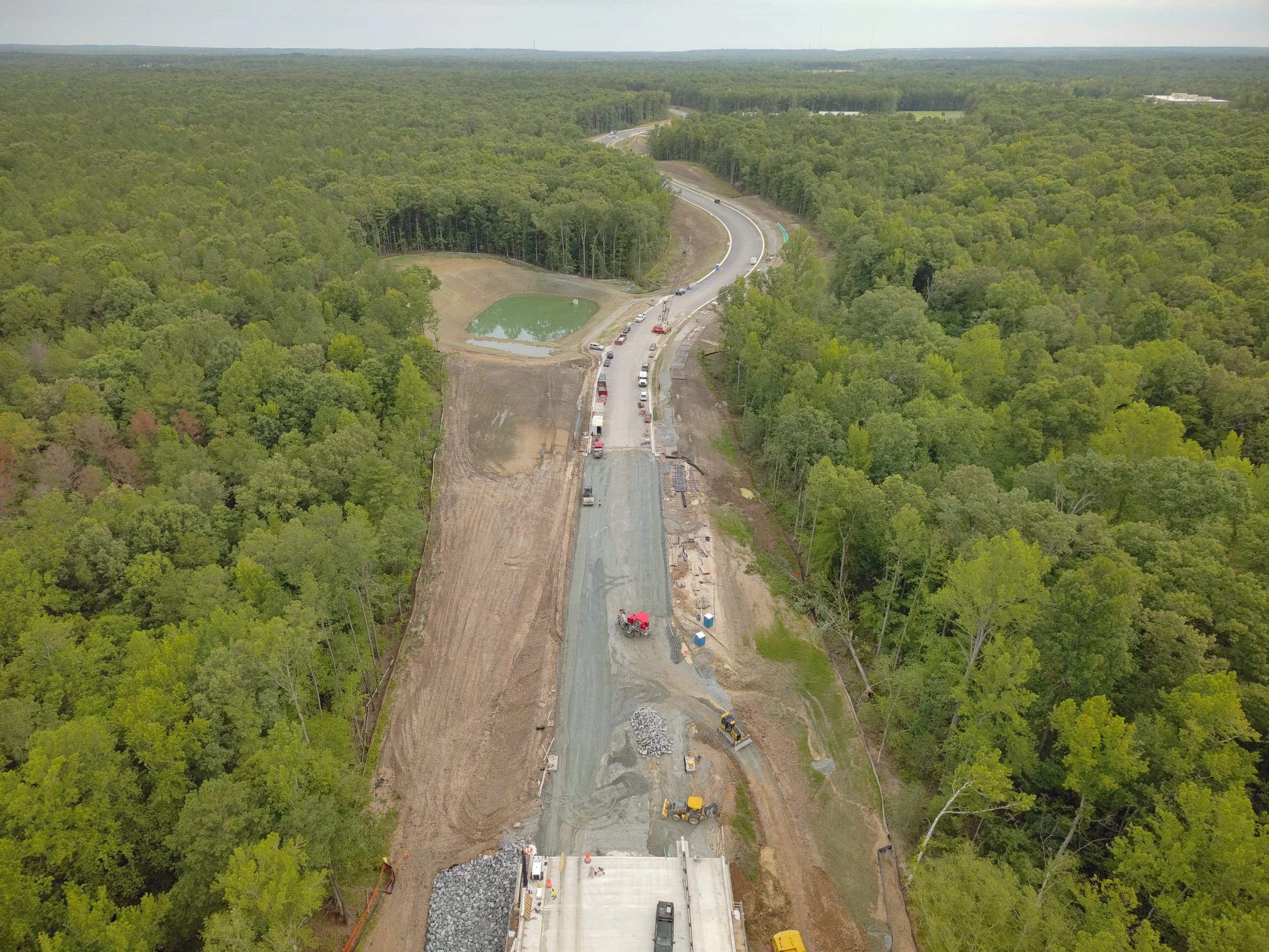 Roadway work continues with curb/underdrain installation and paving to follow. Work on the bridge reaches final stages with sidewalk and railing installation.