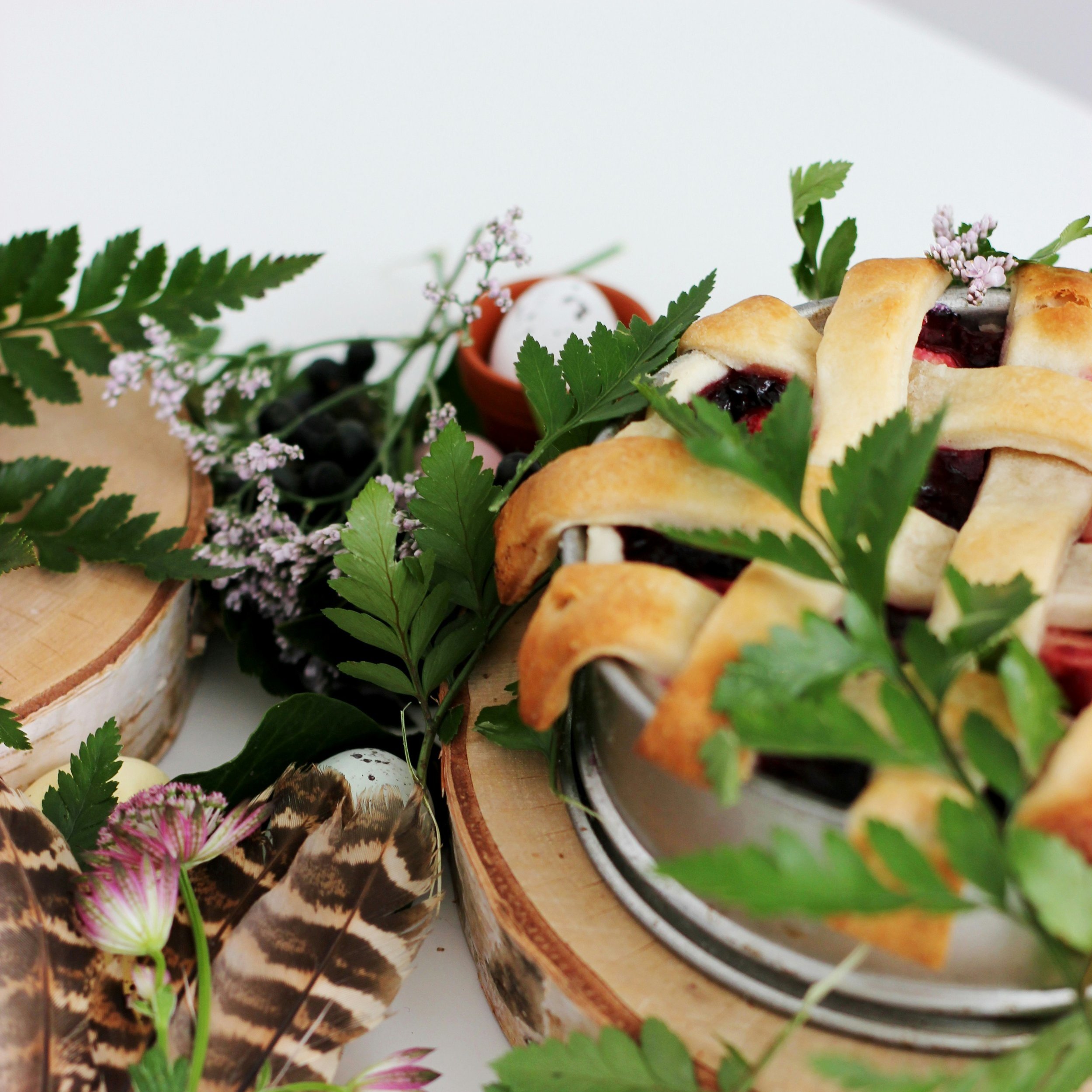 Elegant pastry desserts garnished with vibrant sprigs of green leaves and small flowers, against a crisp white tablecloth set for a wedding, party, luncheon or event. Great for weekend stays, small weddings, post wedding events and groups.