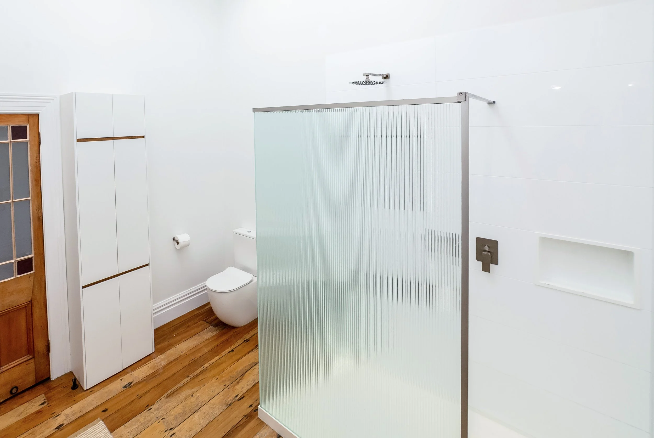 Large, light and airy white bathroom with oversize fluted glass shower, storage cupboards and light wood floors. Great for weekend stays, small weddings and post wedding events, group gatherings, celebrations and holidays.