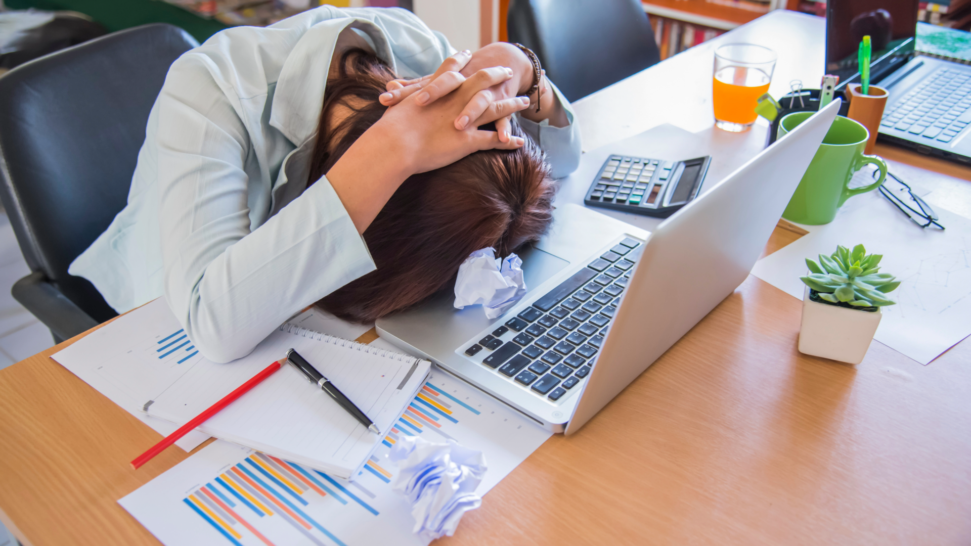 Woman with her head down on her laptop. Struggling with her business finances.