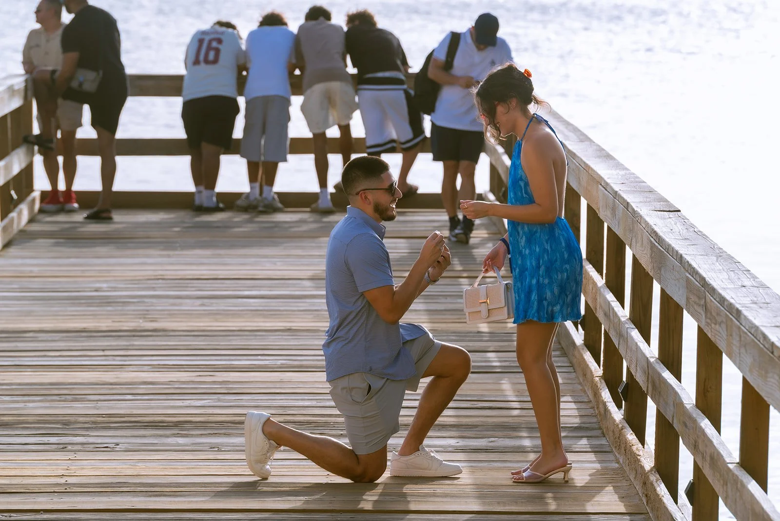 A man kneels in front of his lady on a deck in Old San Juan