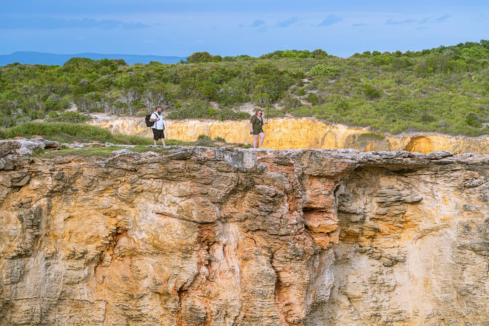 A couple walks above a cliff in Faro Los Morrillos, Cabo Rojo, Puerto Rico
