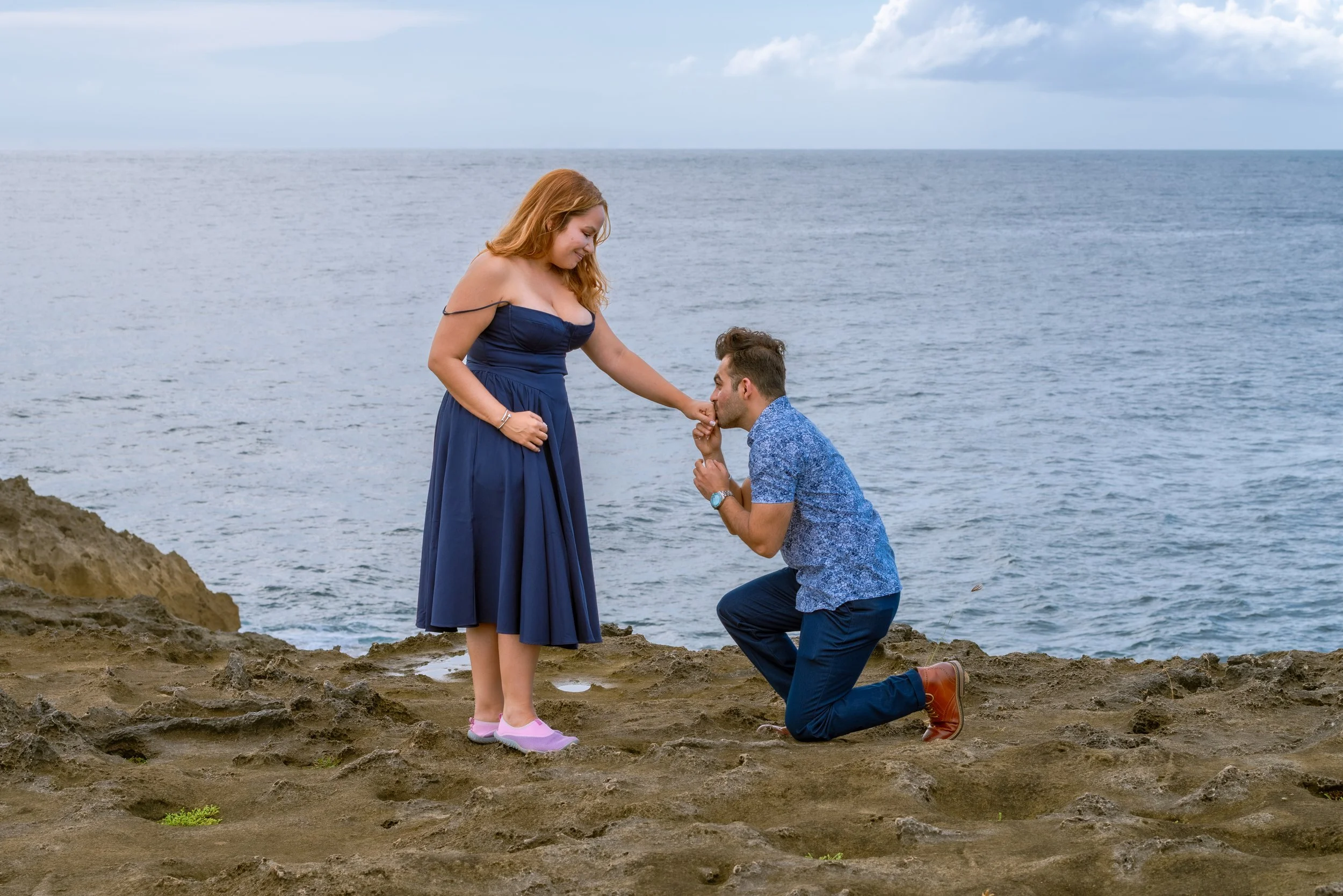 Man proposing to his partner by the ocean during a surprise proposal in Puerto Rico.
