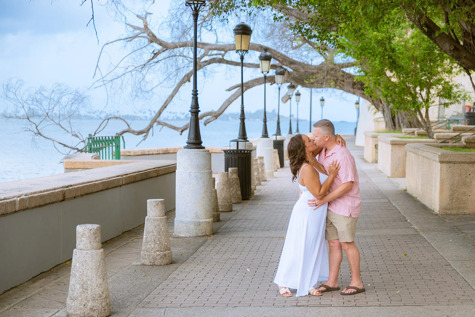 A couple kisses under the trees in Paseo La Princesa, Old San Juan