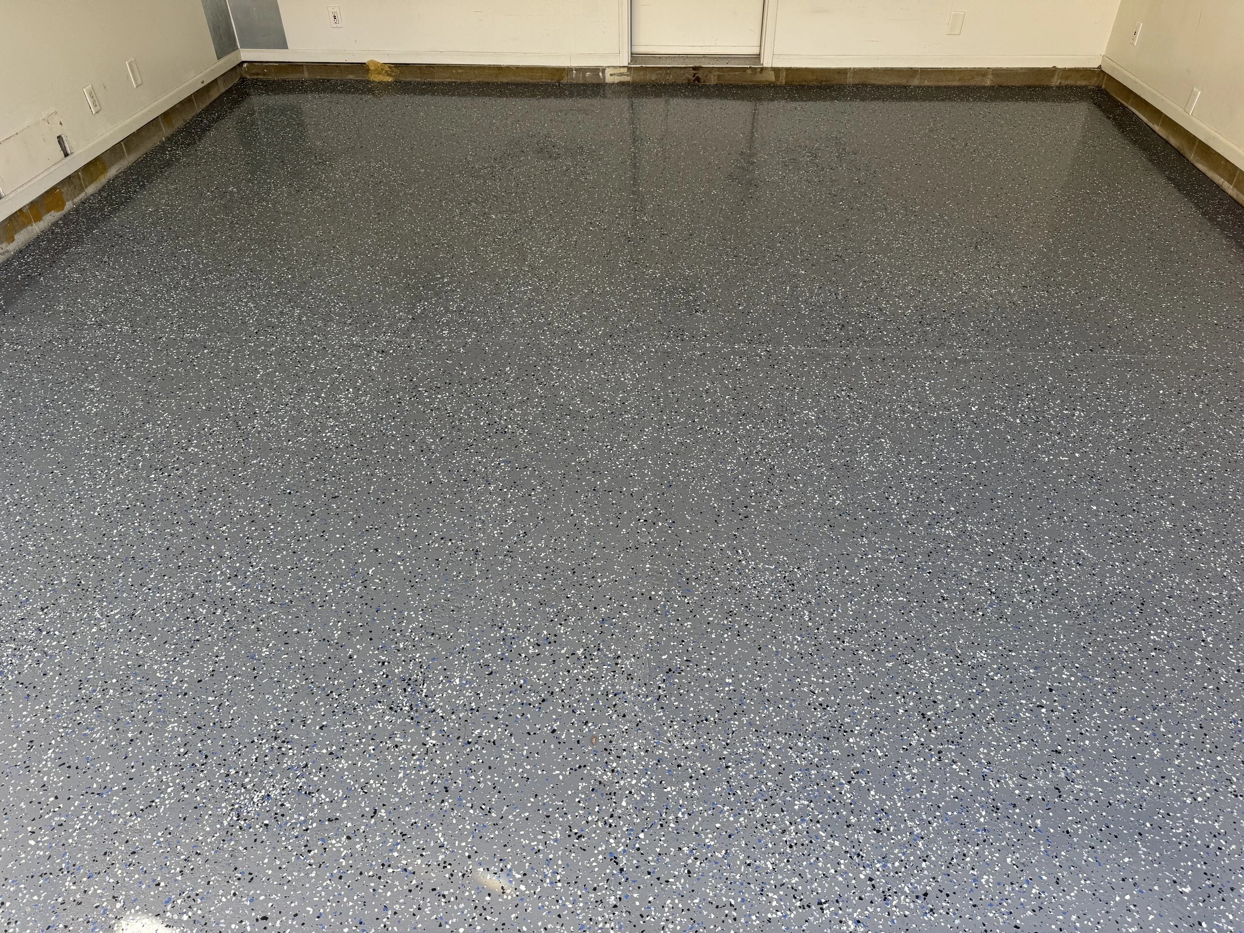 High-performance, multi-flake epoxy floor coating system applied to a pristine shop floor.